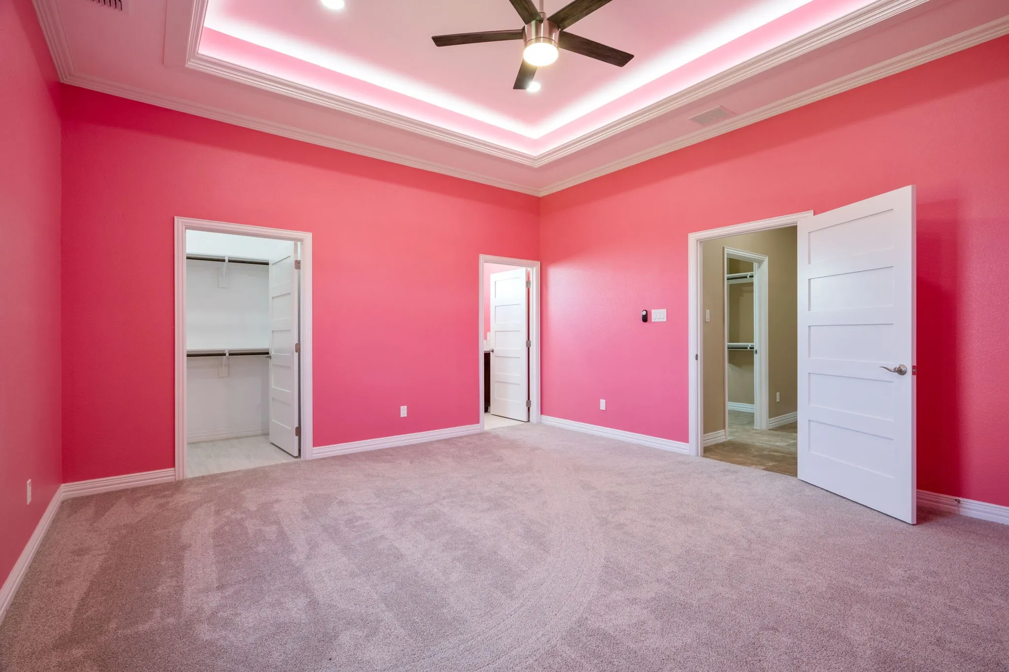 Spacious room featuring tray ceiling with recessed lighting, ceiling fan, and light-toned carpet flooring