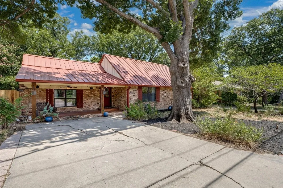 Brick exterior with a red metal roof and a covered porch