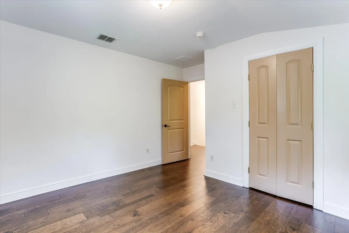 Room featuring wood-finish flooring, white baseboards, and a neutral wall palette