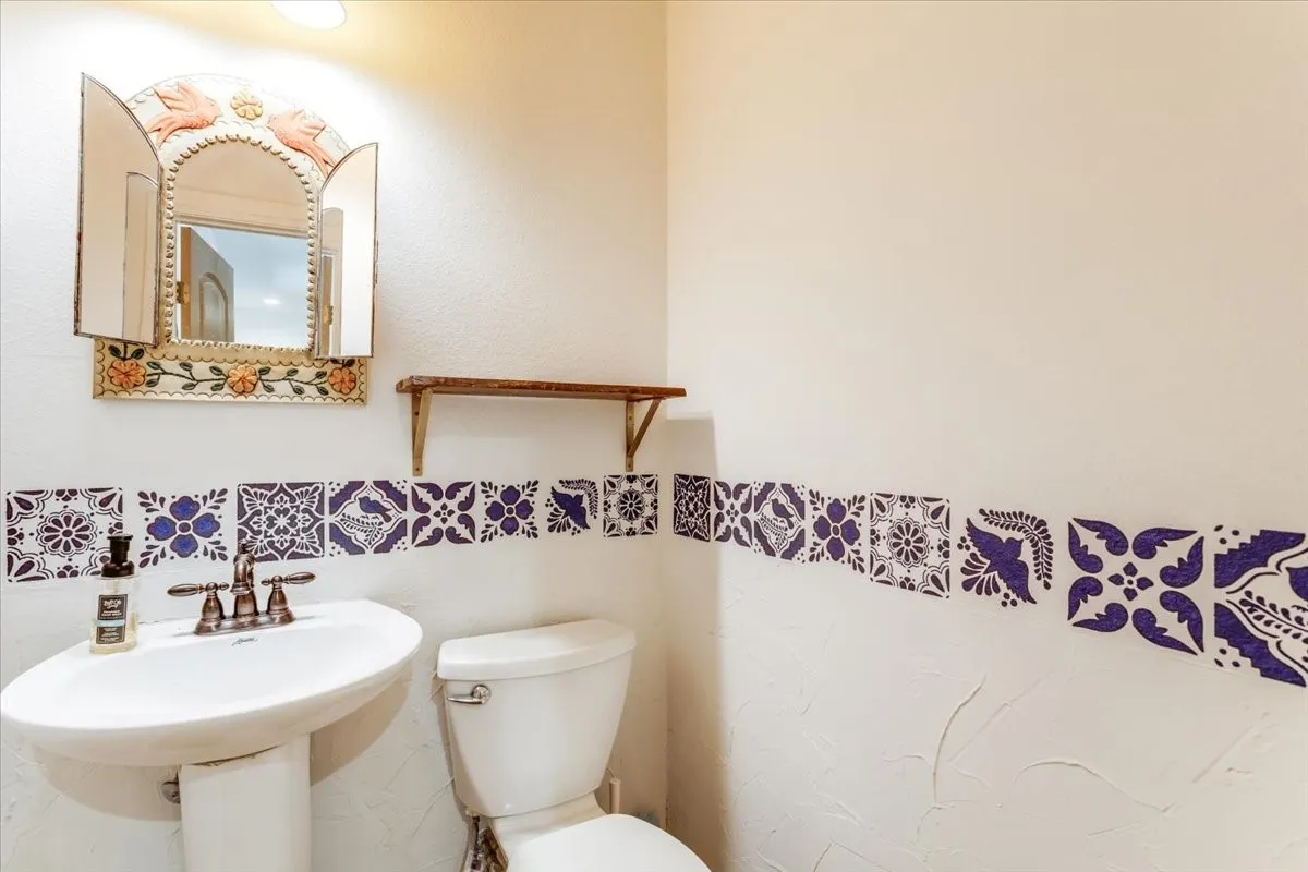 Pedestal sink with a two-handle faucet, accompanied by a white toilet