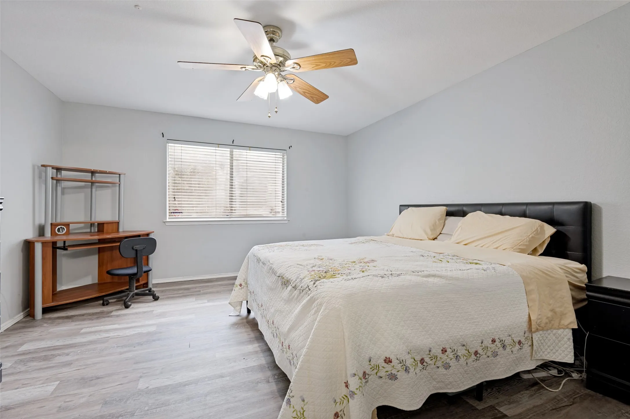 Window with blinds, wood-finish flooring, and a ceiling fan
