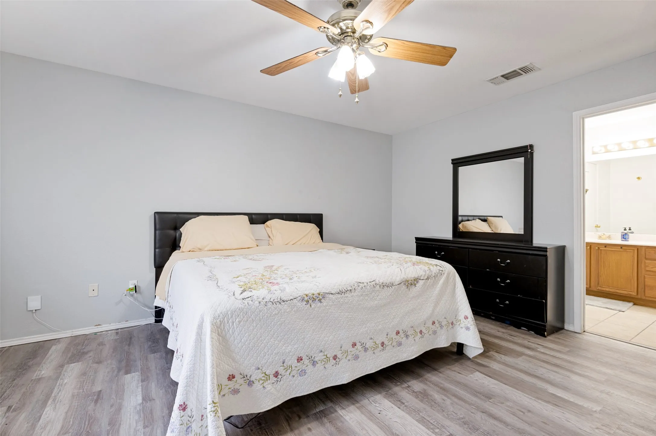Wood-finish flooring with light gray walls and a ceiling fan