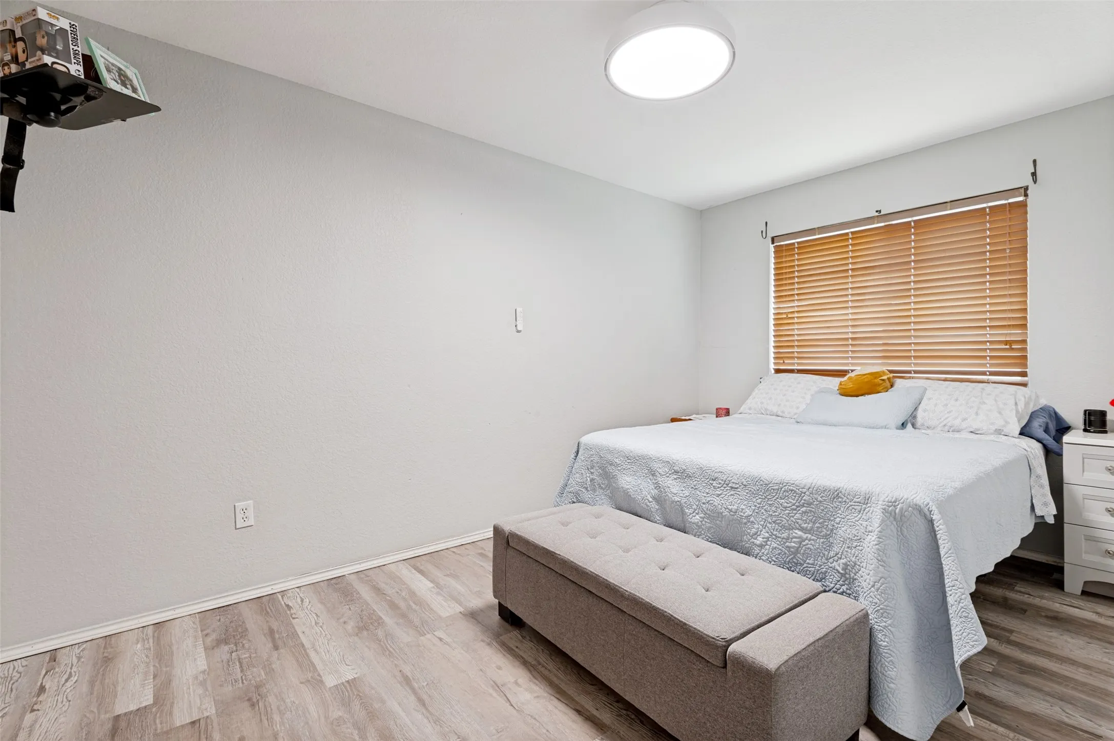 Recessed lighting fixture, wood-finish flooring, window with horizontal blinds