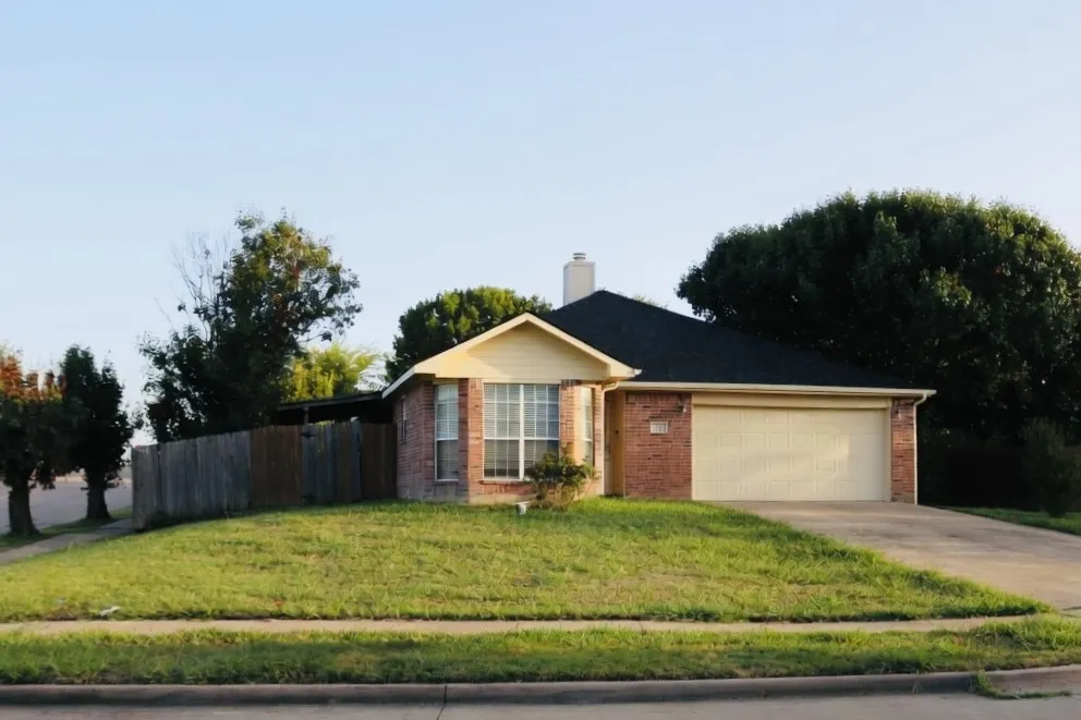 Brick exterior with a prominent bay window, attached garage, and a sloped driveway
