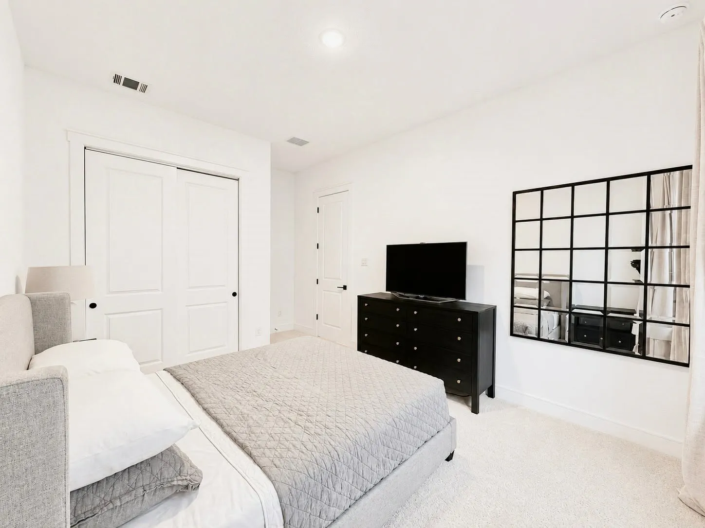 Bright interior room featuring white walls and plush carpet flooring