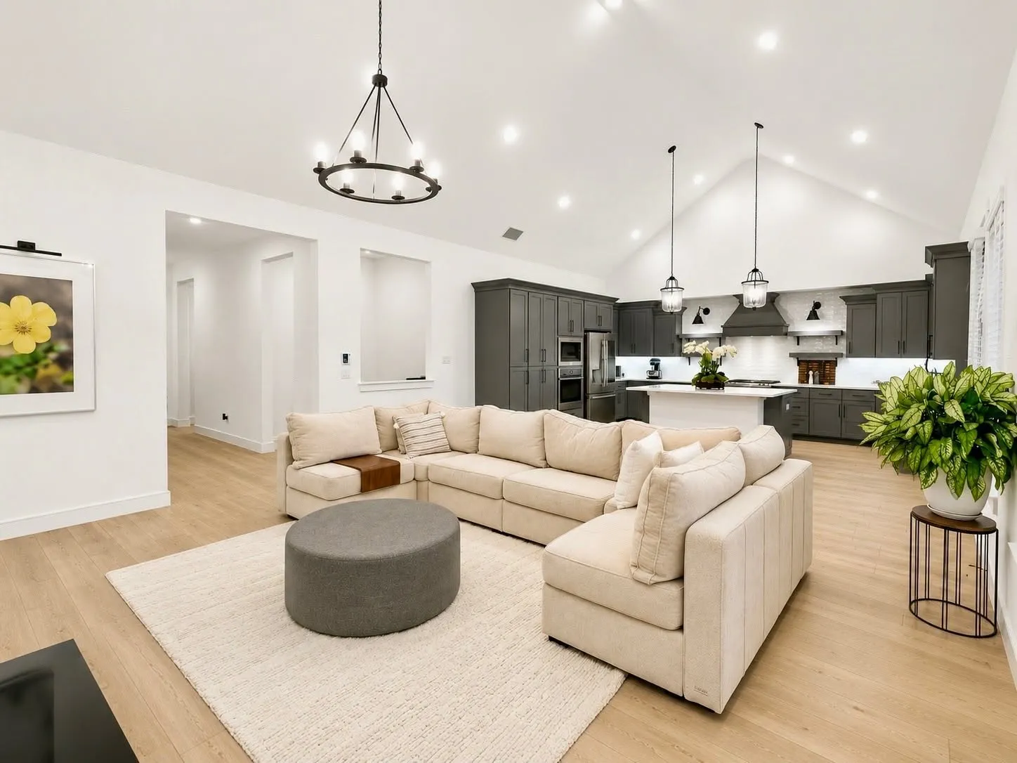 Open-concept living space featuring a vaulted ceiling and light wood-finish flooring