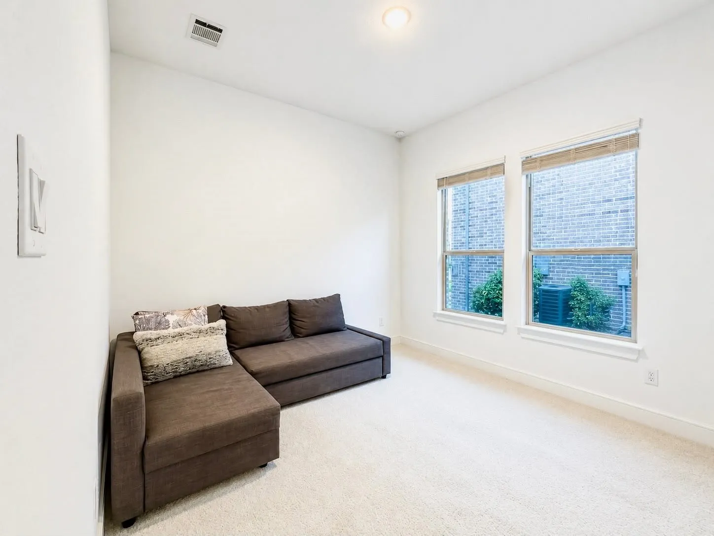 Carpeted room featuring a neutral color palette, white walls, and a white paneled door with matte black hardware