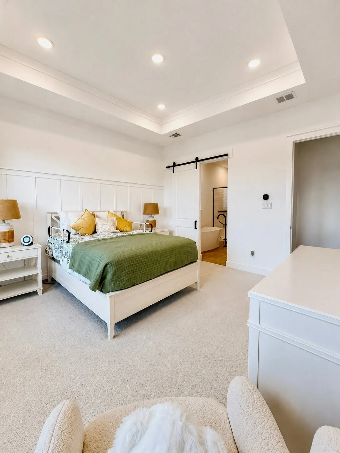 Large bedroom with spa-style bath featuring freestanding tub, oversized shower, dual vanities, barn door, walk-in closet.