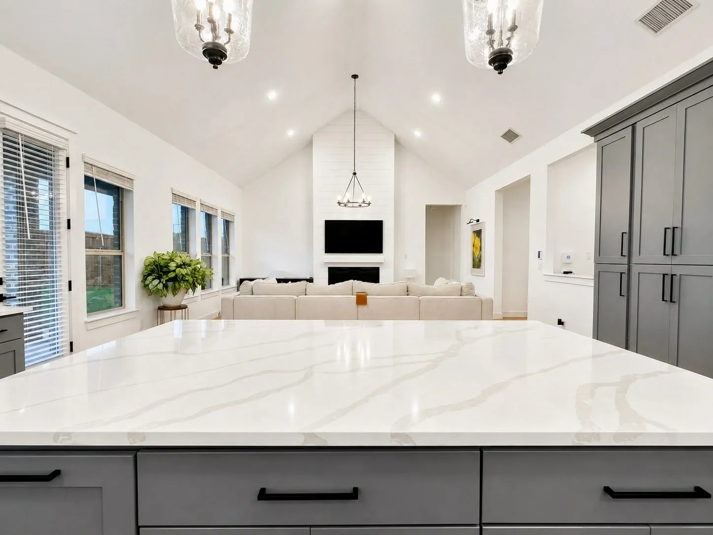 Oversized island, quartz countertops, gas cooktop, stainless appliances, custom vent hood