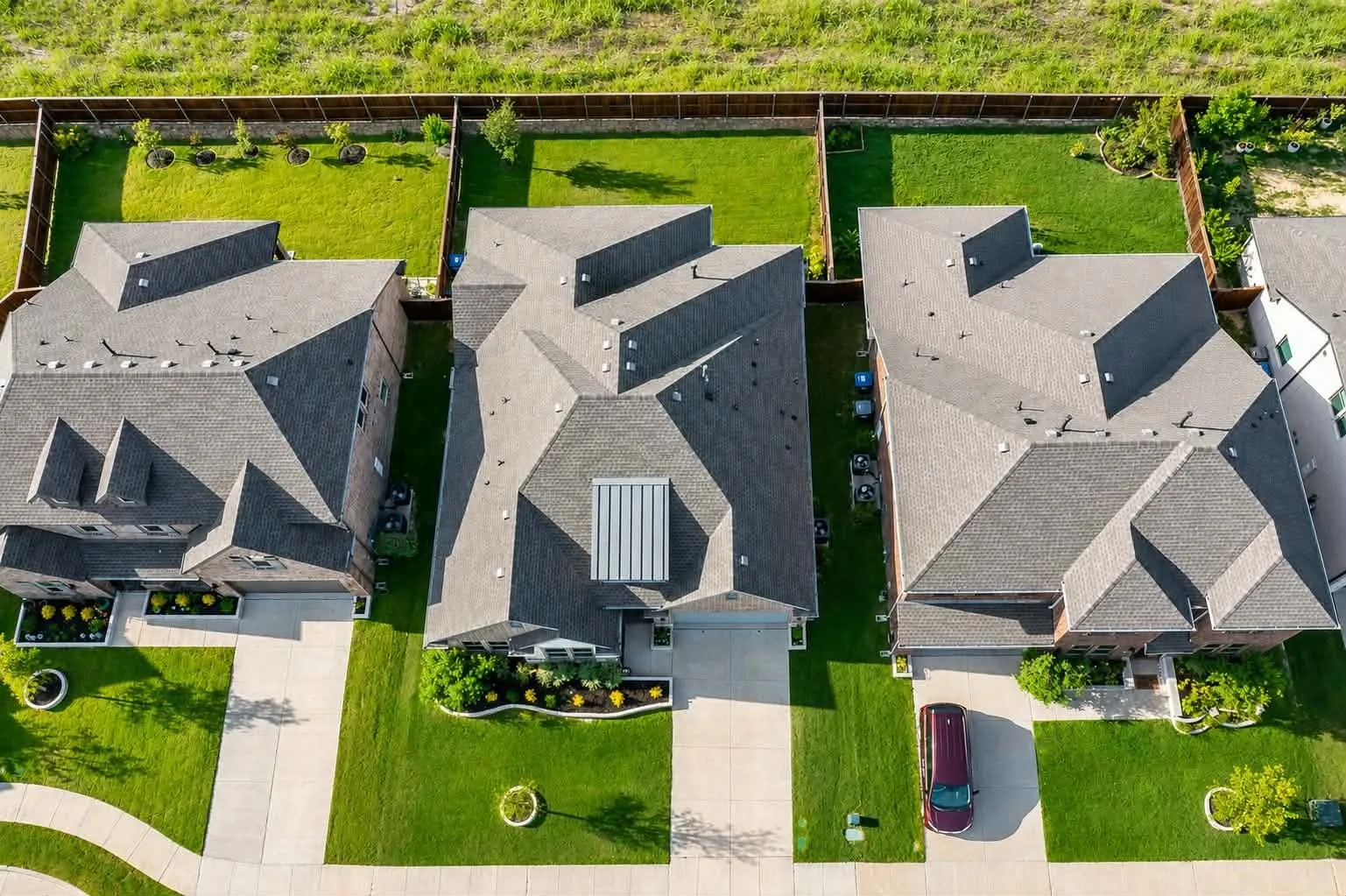 Aerial perspective showcasing the property's composition with a gray shingle roof and a front-facing attached garage