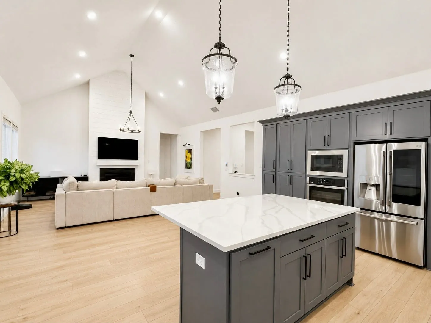 Oversized island, quartz countertops, gas cooktop, stainless appliances, custom vent hood