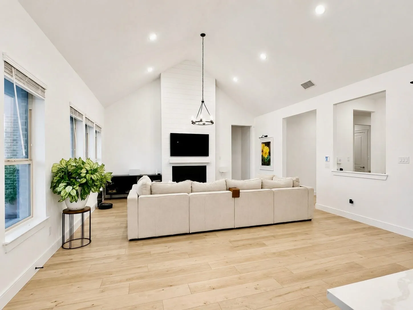 Vaulted ceiling great room featuring light wood-finish flooring
