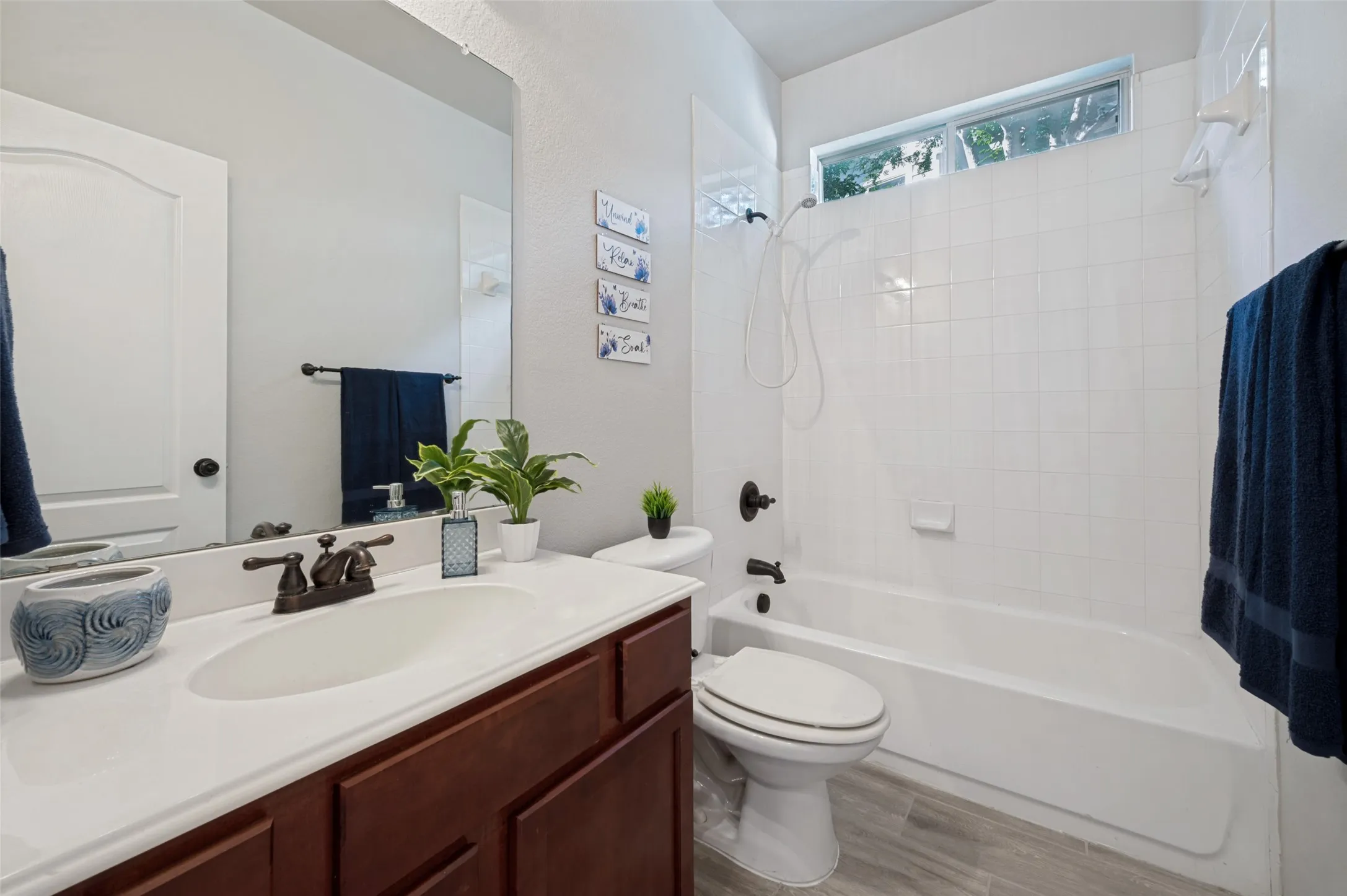 Bathroom featuring a single vanity with a white countertop, a bronze-finish faucet, and a large mirror