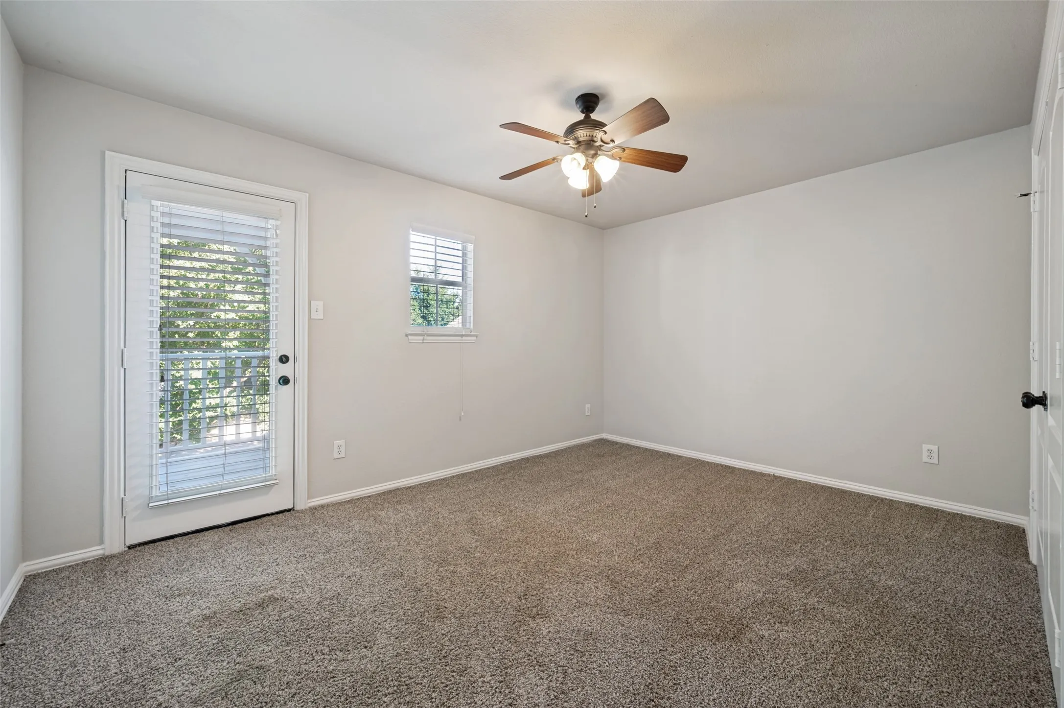 Room featuring neutral wall tones, brown-tone carpet flooring, and a ceiling fan with integrated lighting