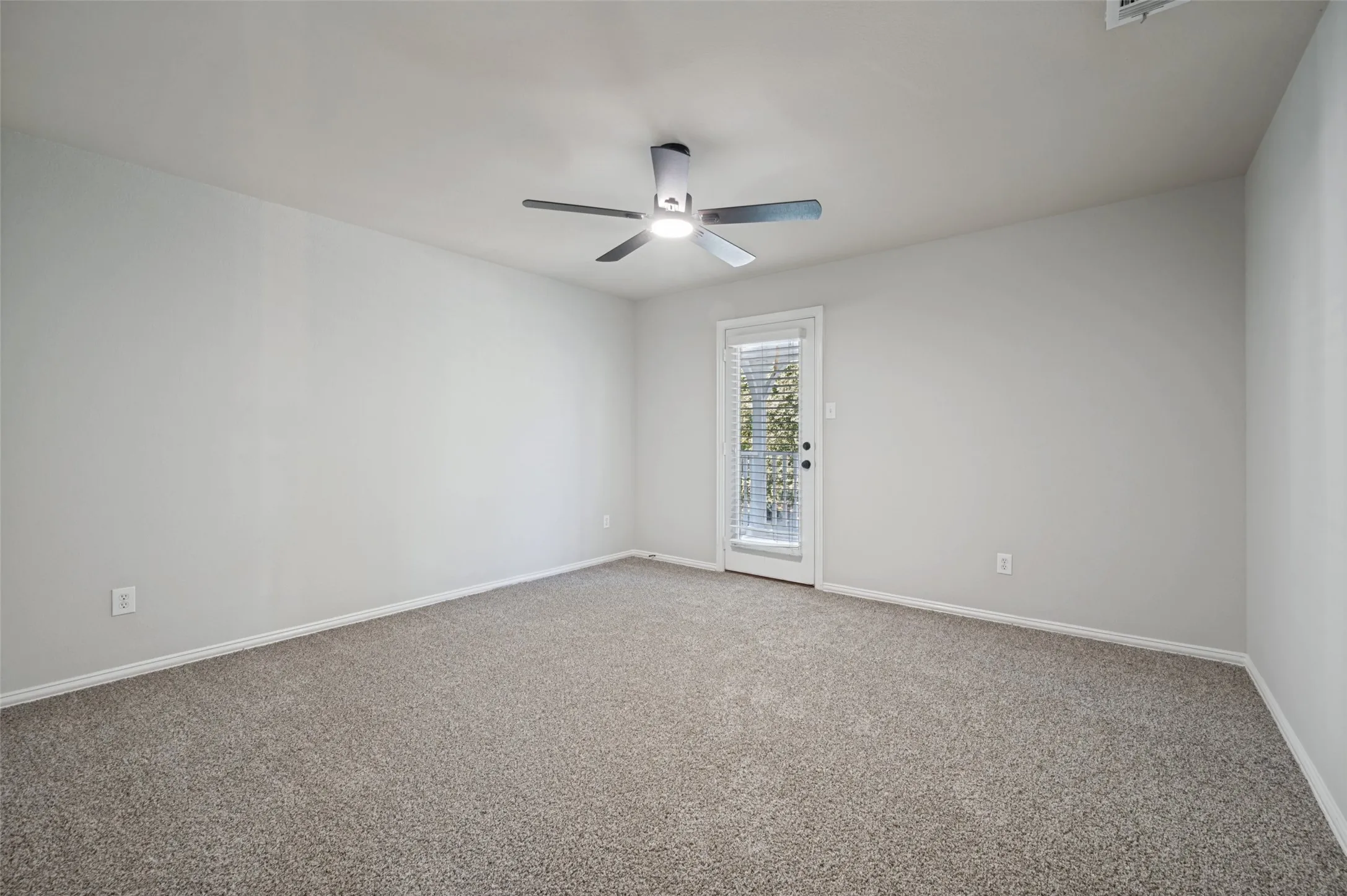 Spacious room featuring neutral carpeting and light-toned walls