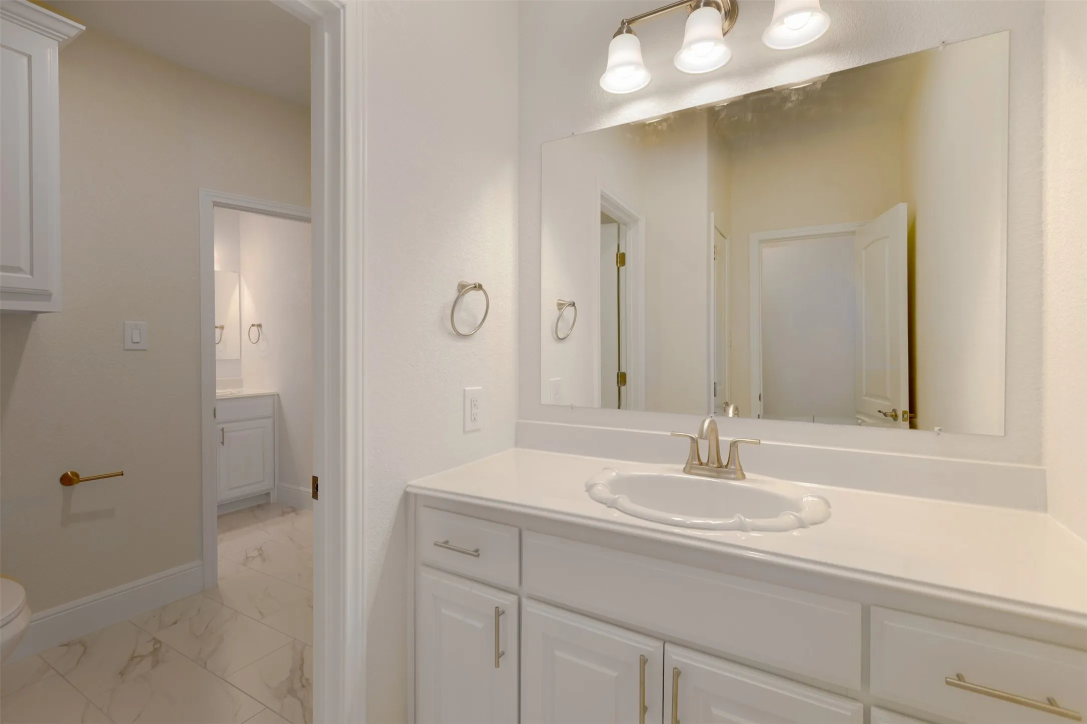 Bathroom featuring vanity and light marble finish floors