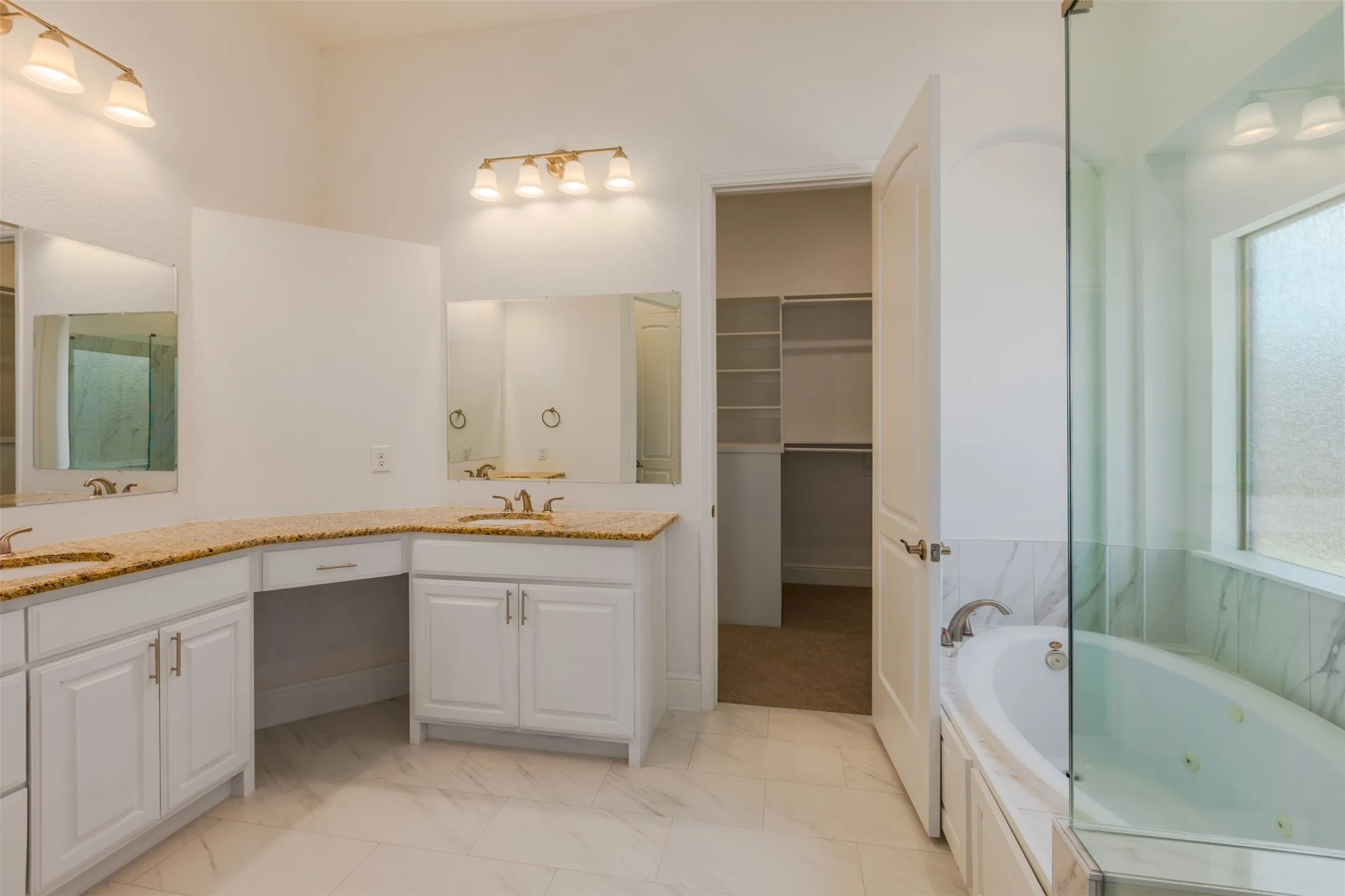 Bathroom featuring double vanity with a tub and a separated shower