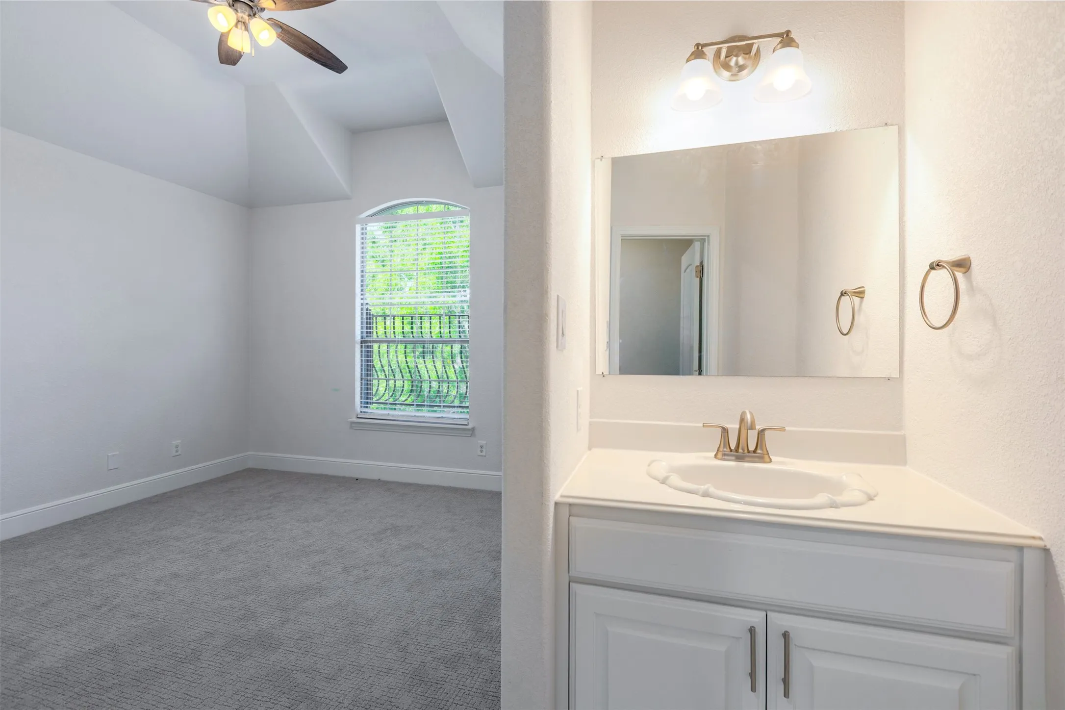 Bathroom with light carpet, vanity, ceiling fan, and a textured wall