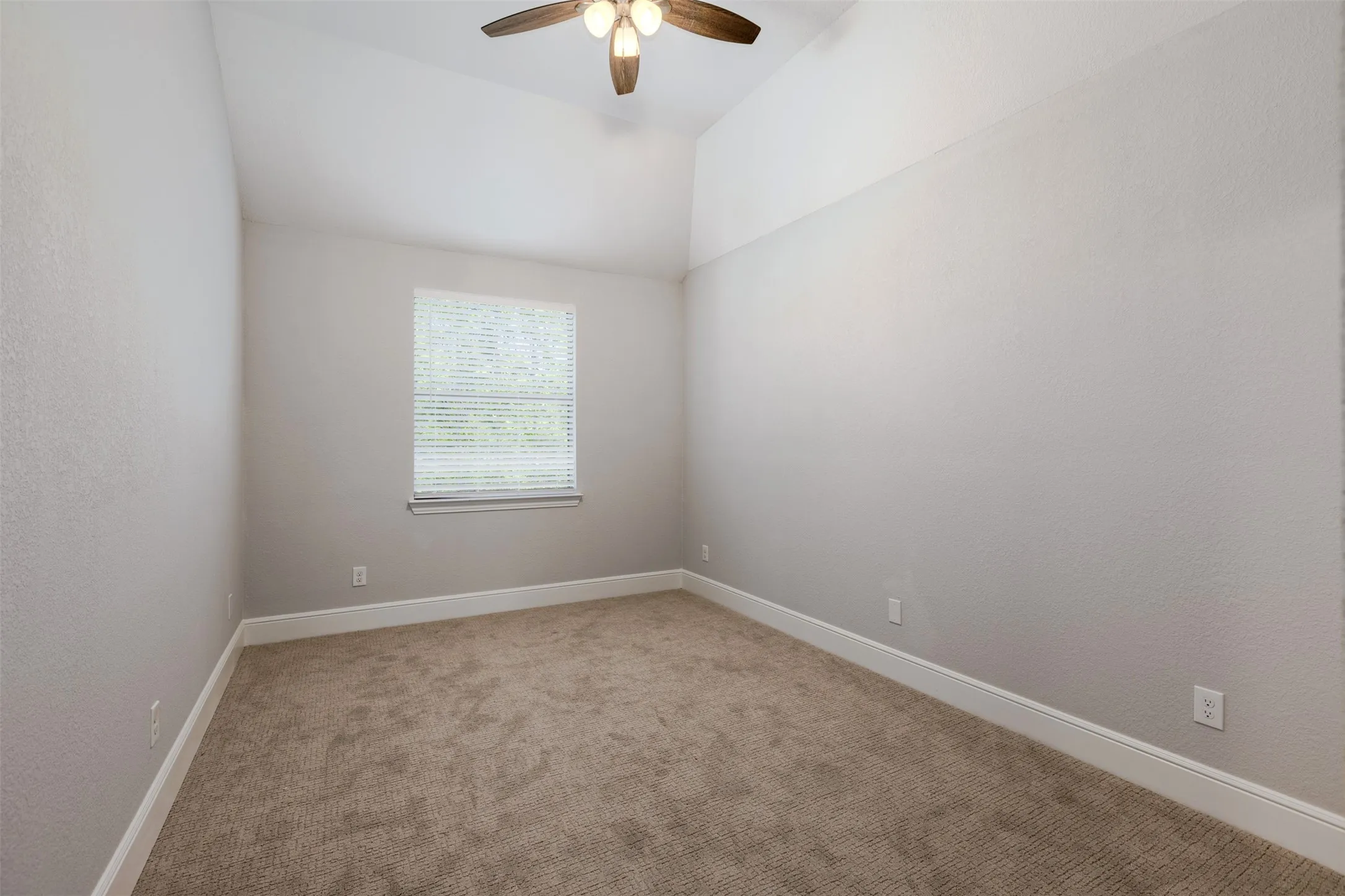 Bedroom with light colored carpet, ceiling fan, and lofted ceiling