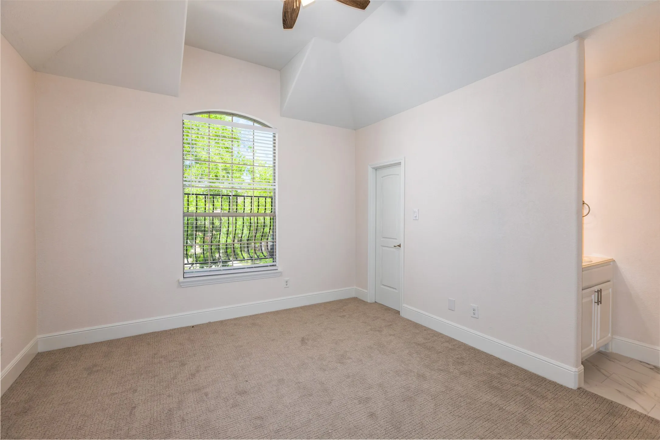 Bedroom with ceiling fan, light colored carpet, and lofted ceiling
