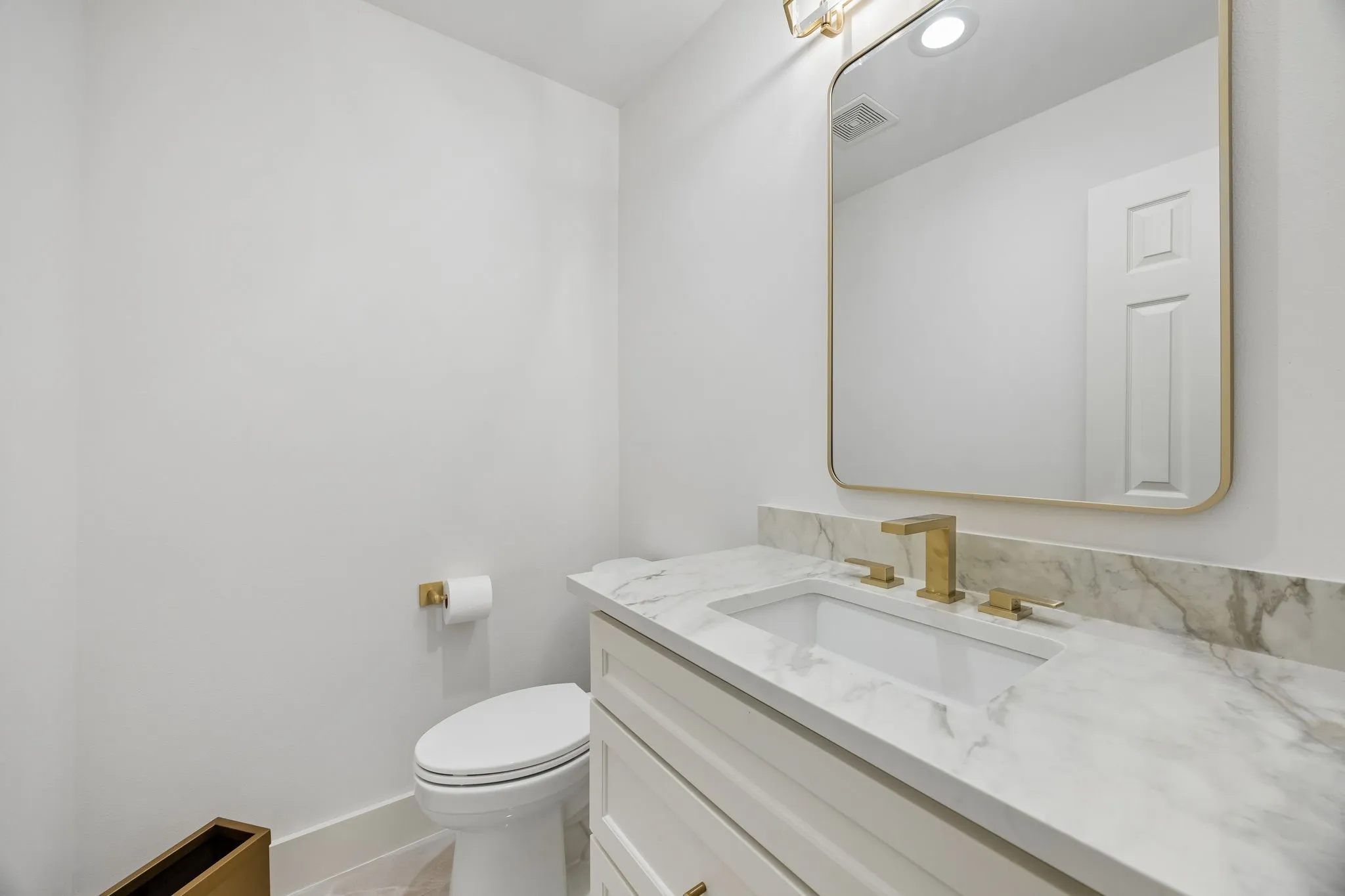 Vanity with light-colored cabinetry, integrated sink, and a stone-finish countertop