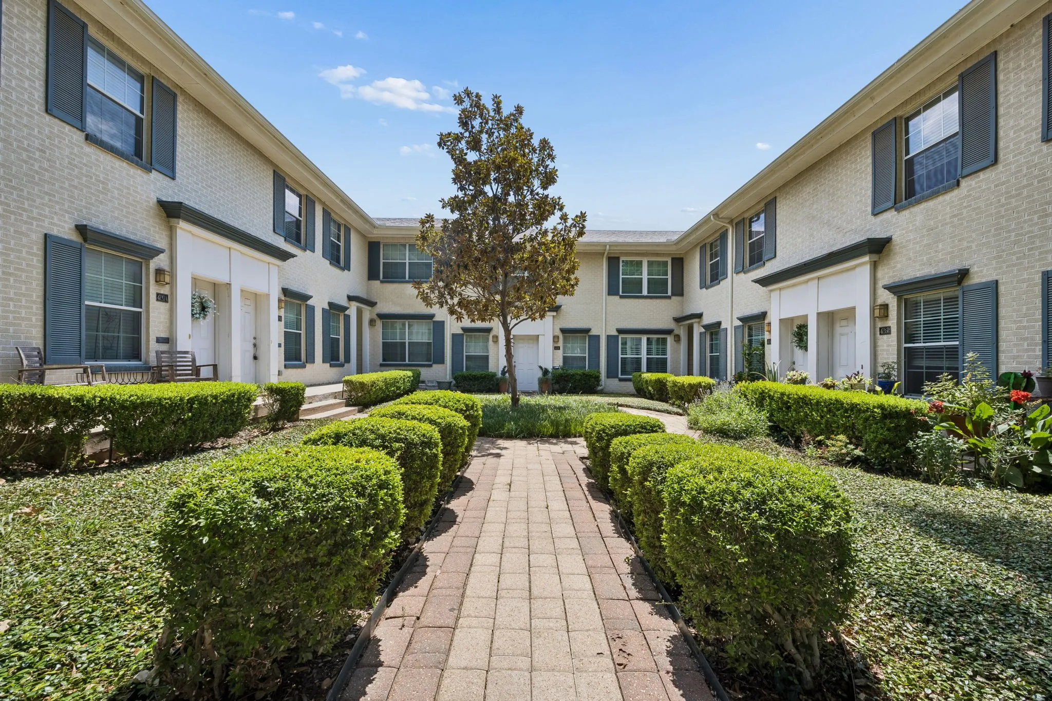 Brick facade townhomes featuring complementary dark shutters