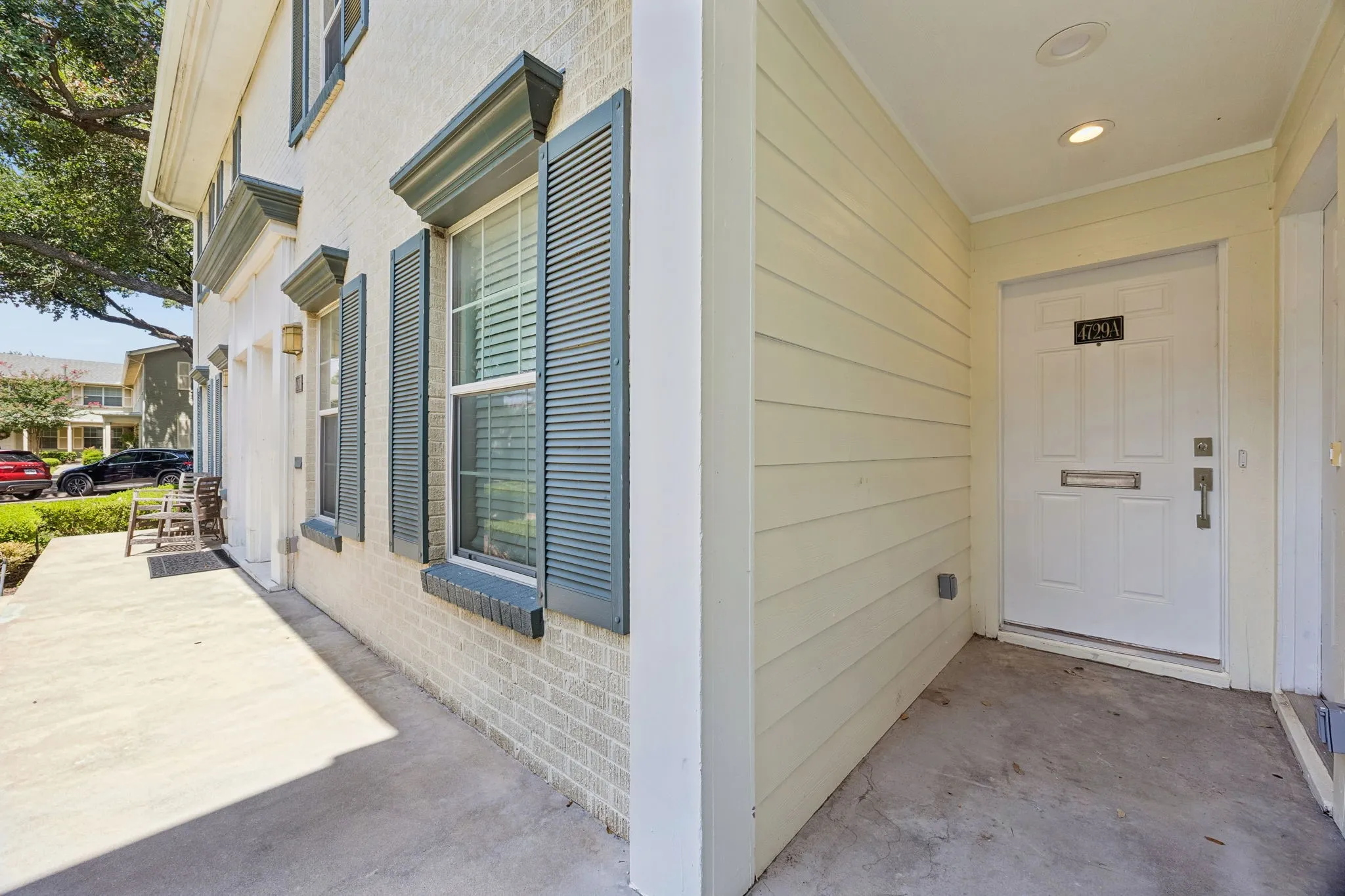 Front entry featuring a paneled door with polished hardware, covered porch, recessed lighting, and horizontal siding