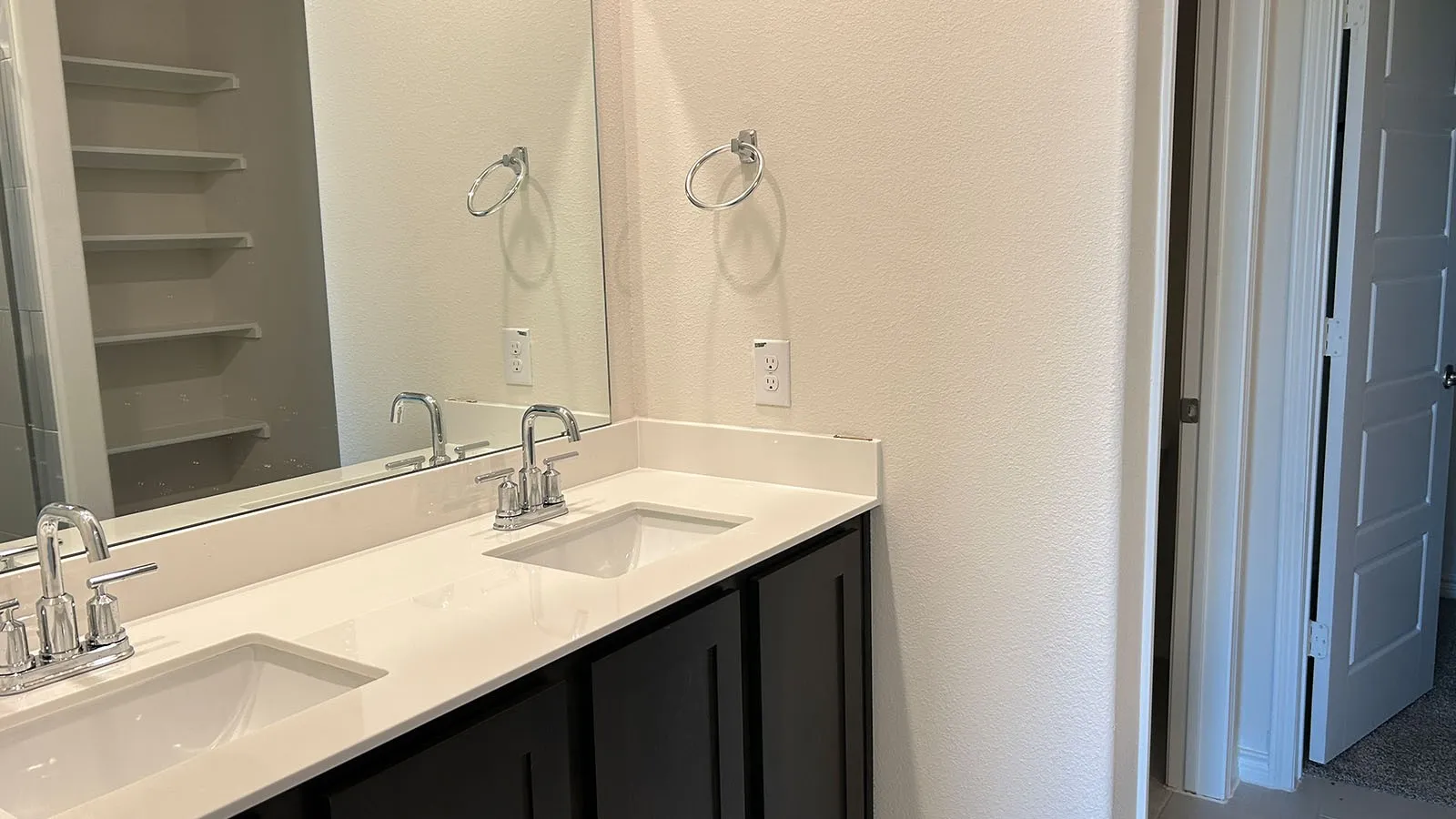 Dual vanity featuring integrated sinks and polished chrome fixtures