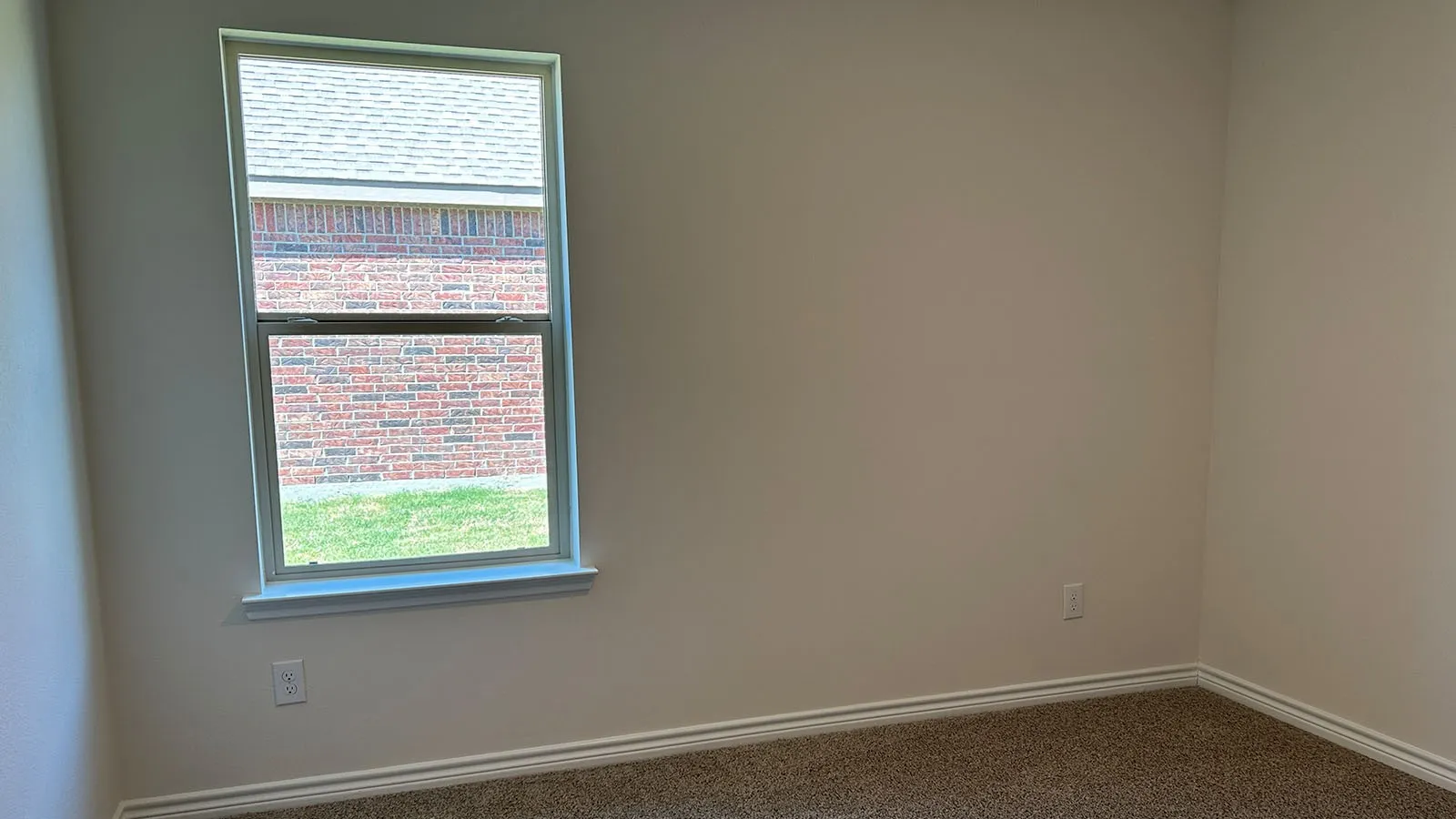 Wall-to-wall carpeting with light-toned walls and a double-hung window