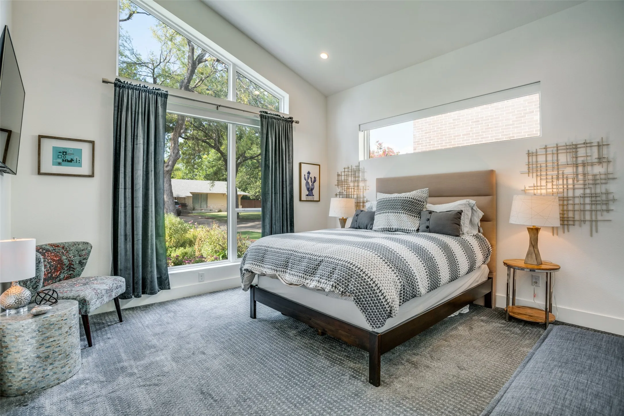 Premium Dream weaver carpeted bedroom featuring vaulted ceiling, large windows and recessed lighting.