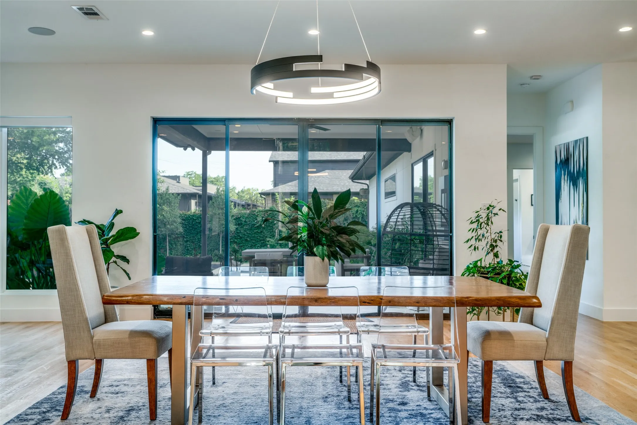 Dining room with designer lighting and outdoor views from the full length sliding doors.