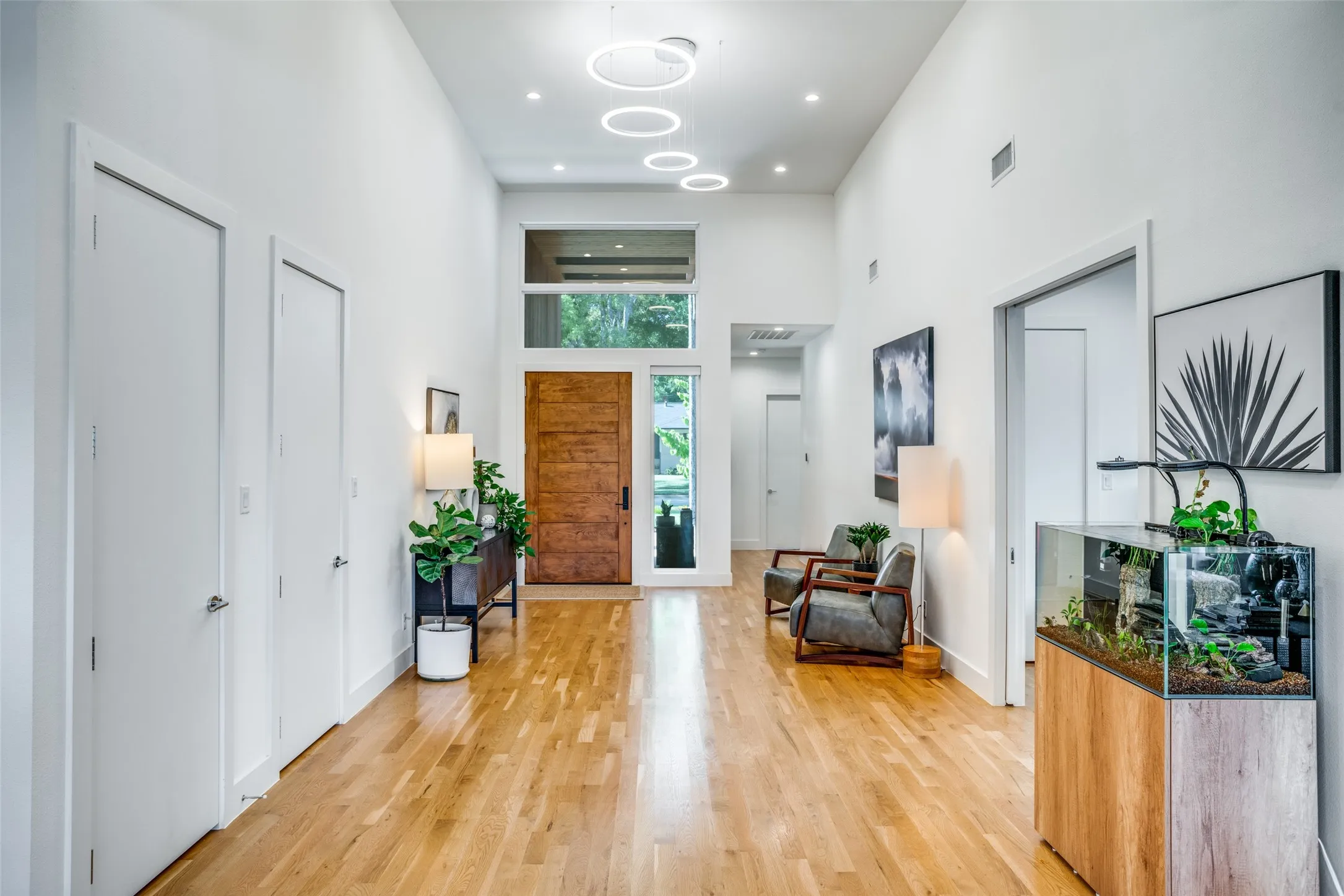 Inviting foyer with a towering ceiling and designer lighting.