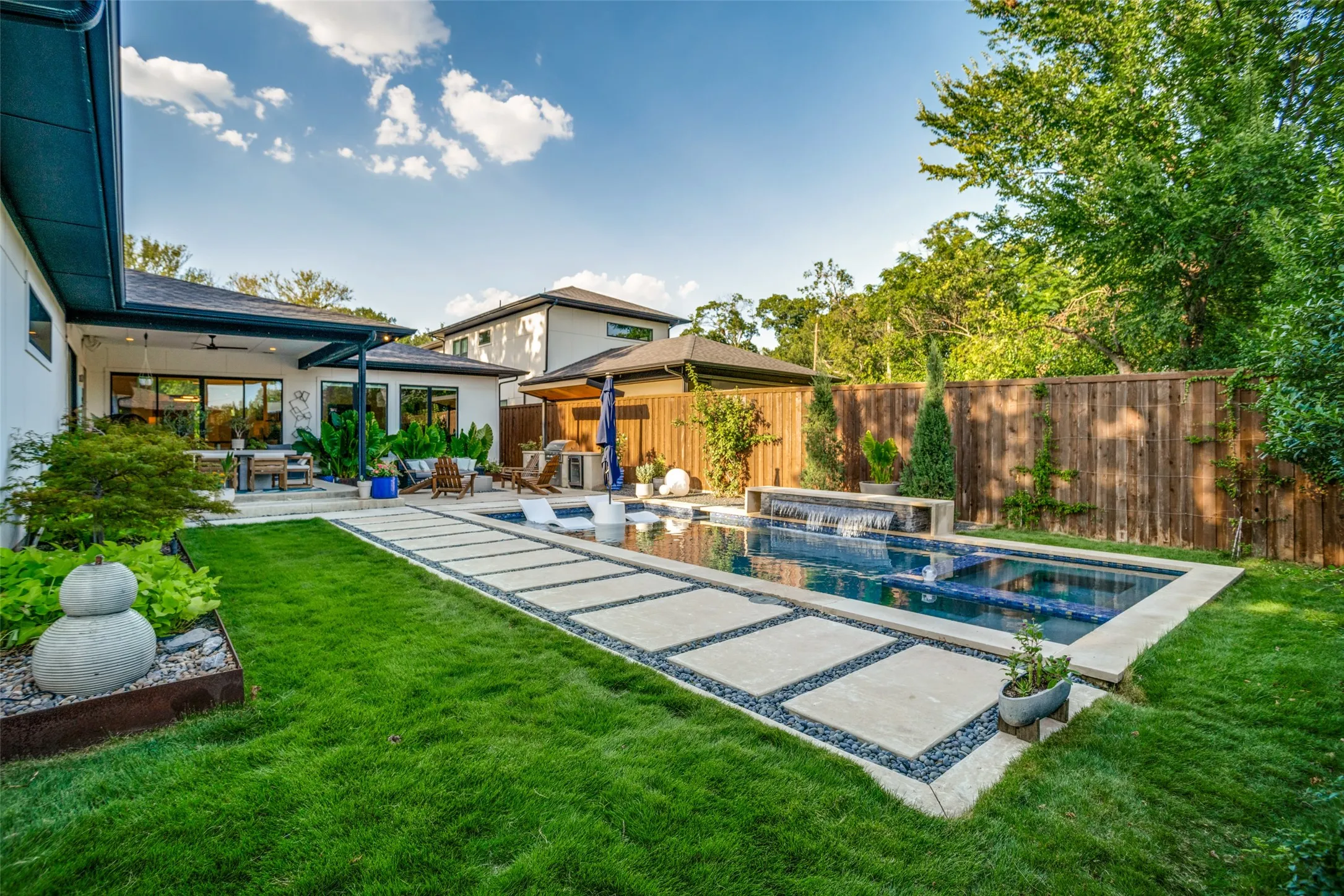 This back yard oasis has everything you need! Multiple sitting areas with in the covered patio and fire pit. Outdoor grilling area with wine fridge. Modern pool/spa with water feature. Landscaped yard with English Ivy and elephant ears that come up every year. Full sprinkler system with rain sensor to keep your yard green all summer.