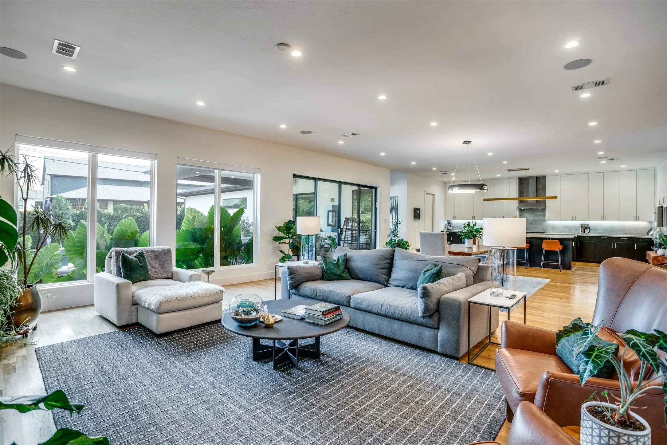 Open concept living-dining-kitchen  featuring large windows with a gorgeous view of the back yard. Electric blinds on windows allow ease of opening and closing without getting off the sofa.