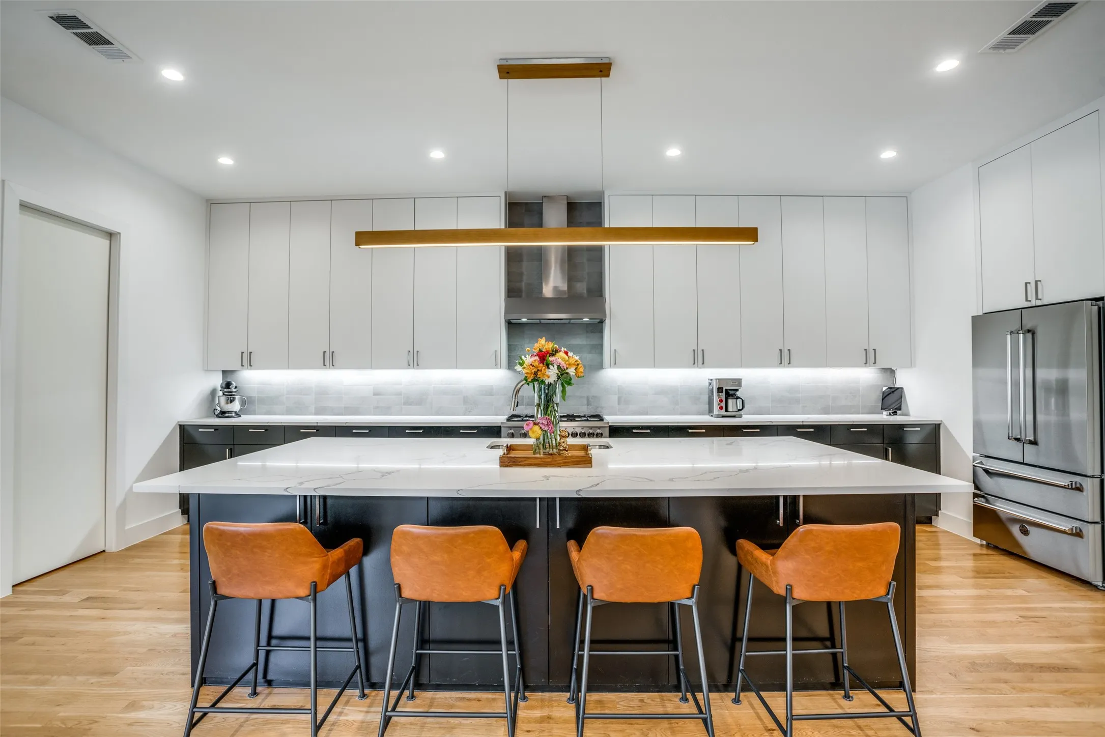 Kitchen with large island and linear designer lighting.