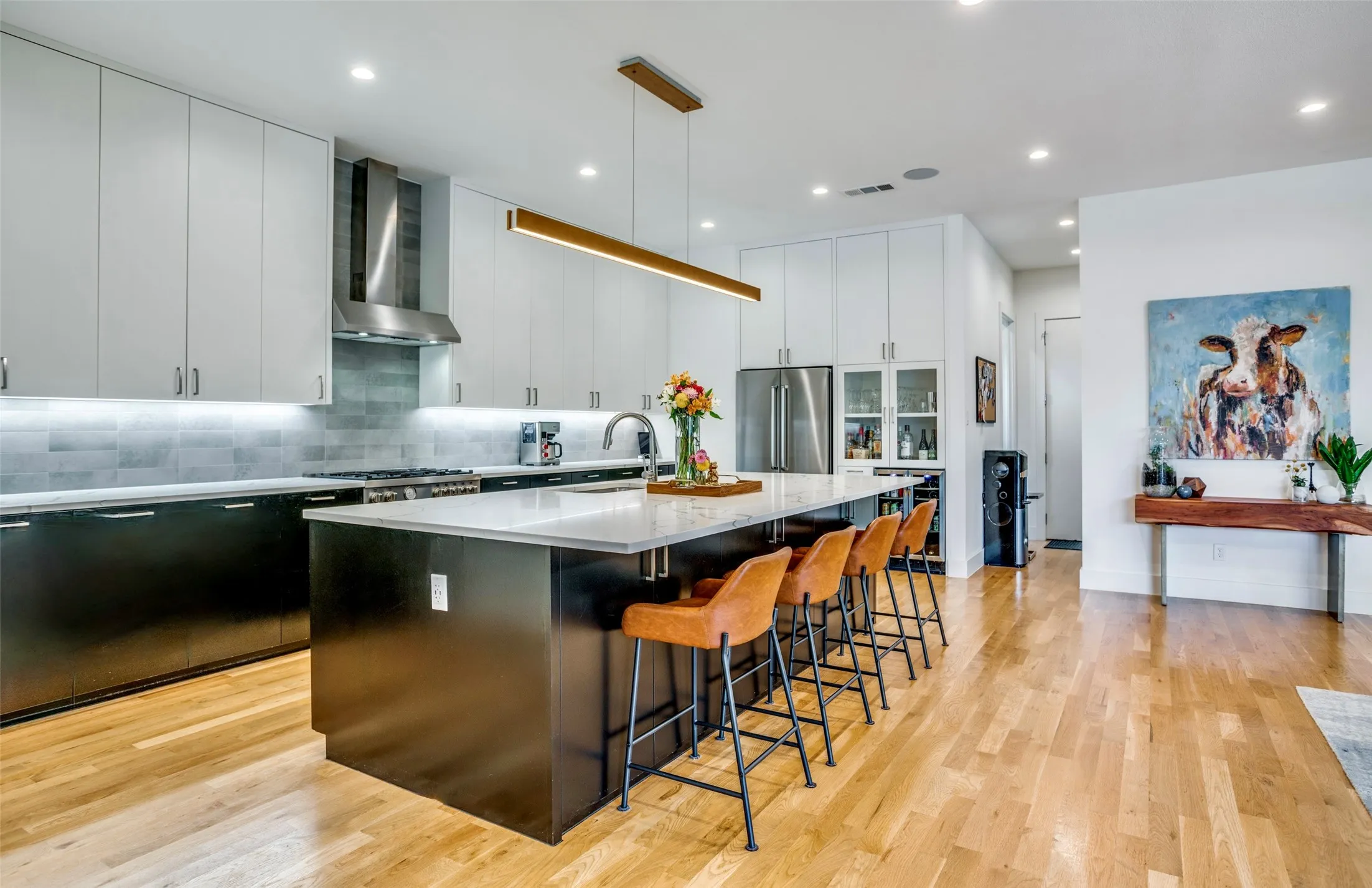 Fully equipped Kitchen with designer ELEGANZA tile backsplash, quartz countertops, a spacious island/breakfast bar with plenty of storage. Bertazzonni under mount canopy vent hood and  gas top stove.