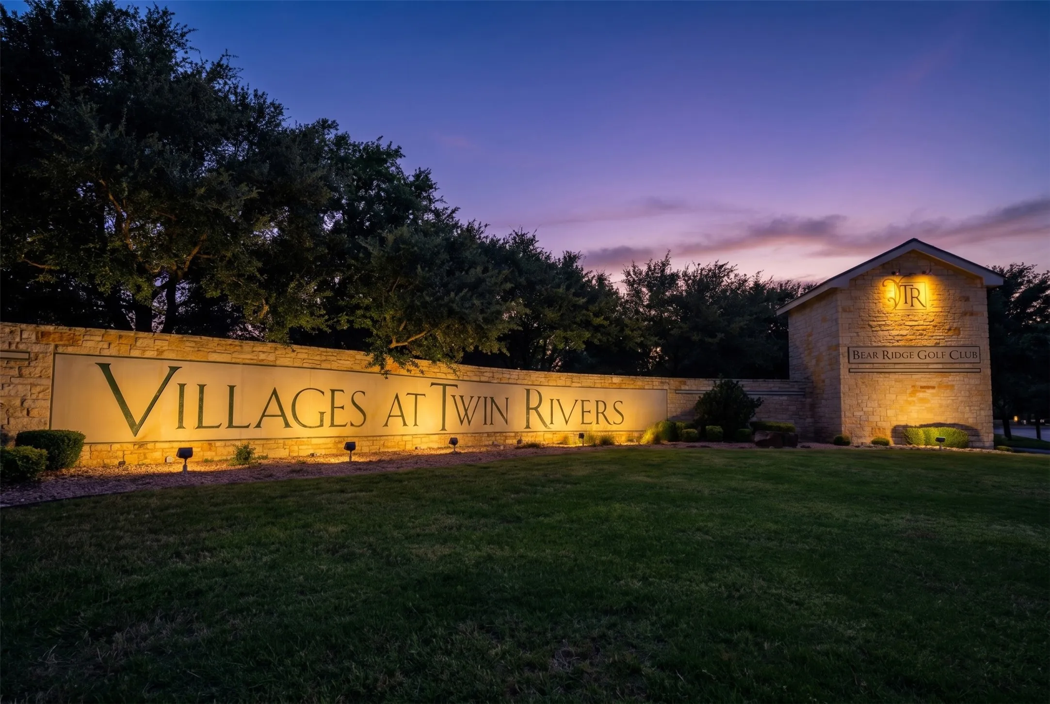 Stone-clad entry monument for "Villages at Twin Rivers" featuring integrated lighting