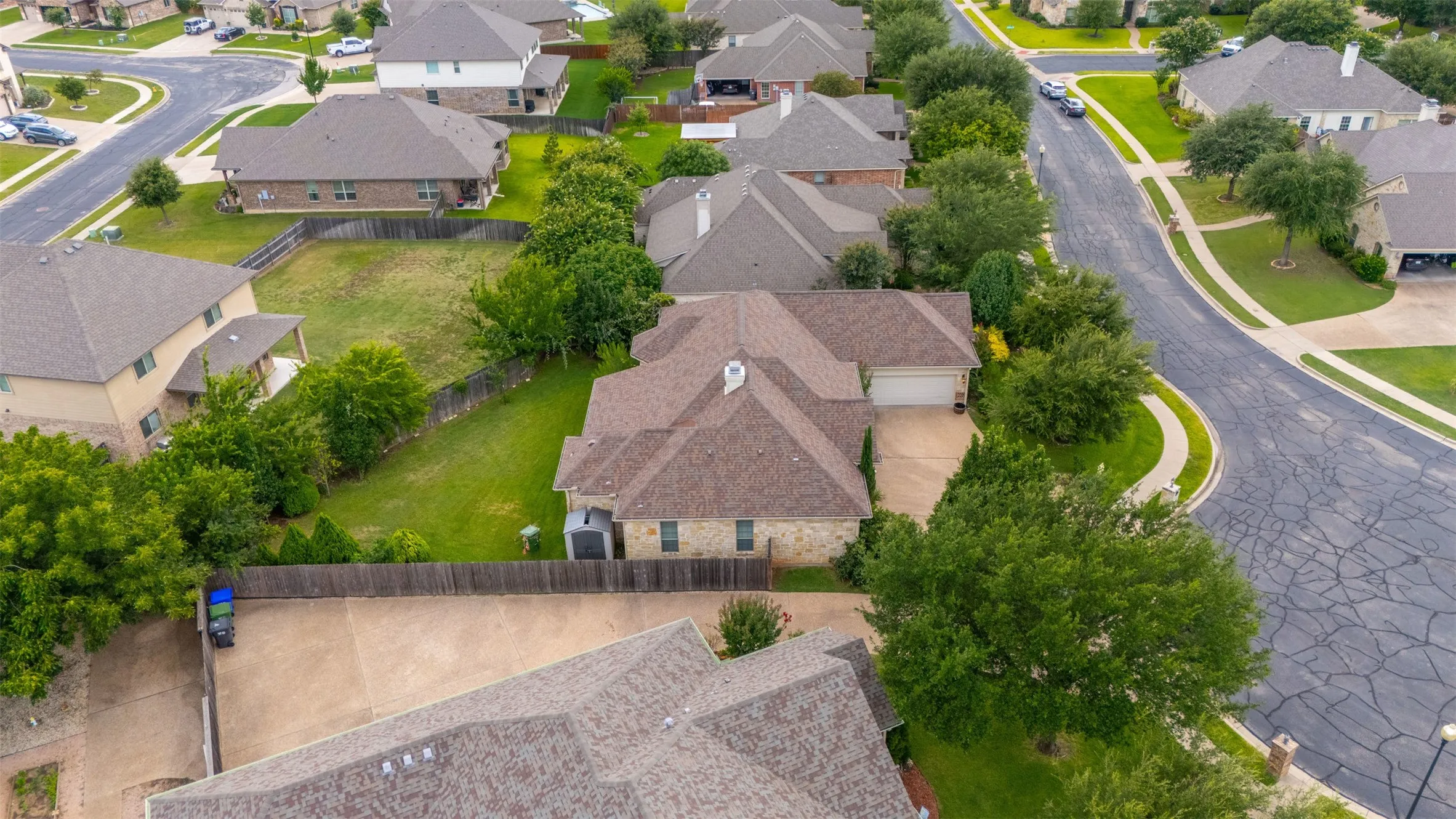 Aerial view of a residential property with a multi-gabled roof and an attached garage