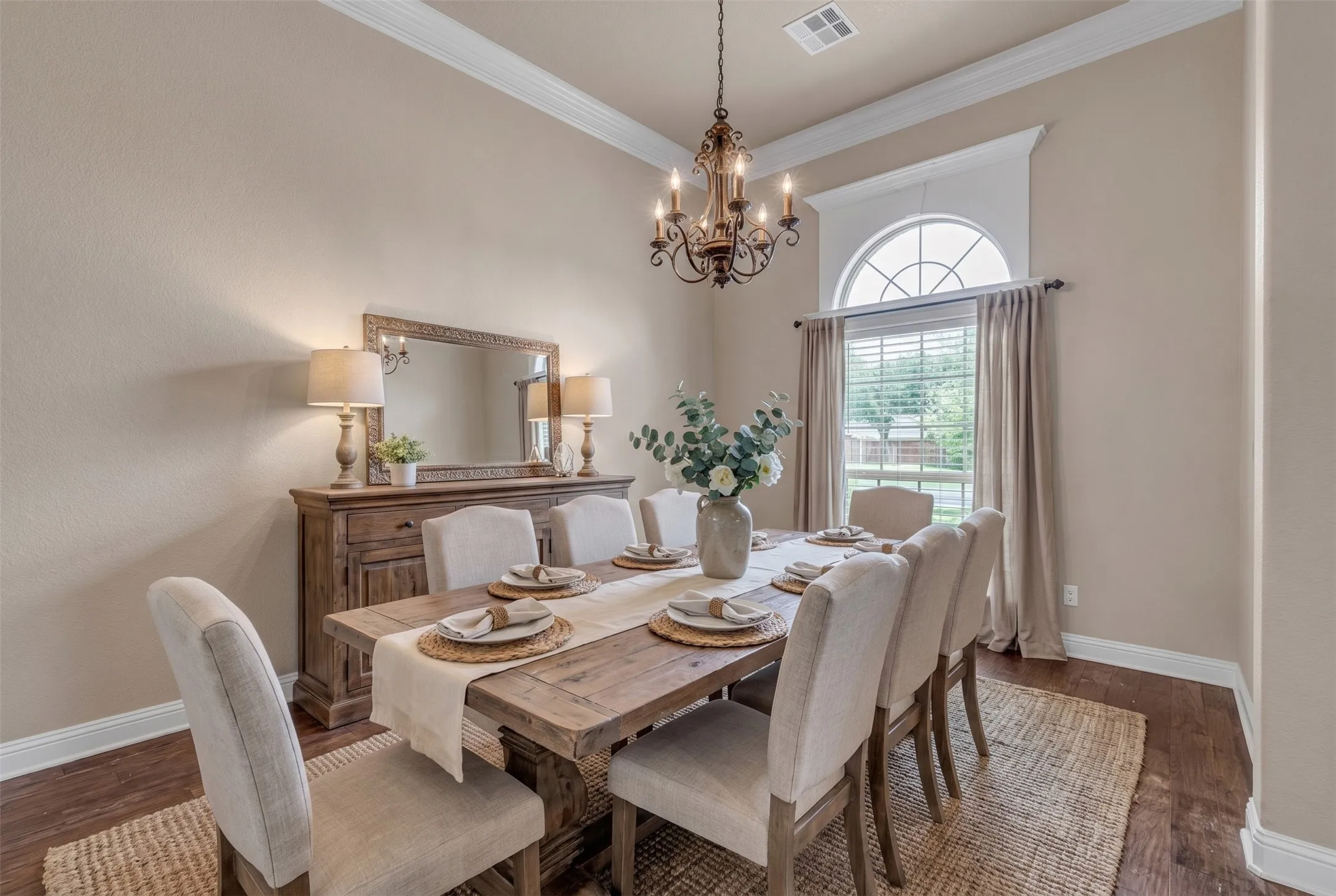 Formal dining area featuring a decorative chandelier, crown molding, and wood-finish flooring