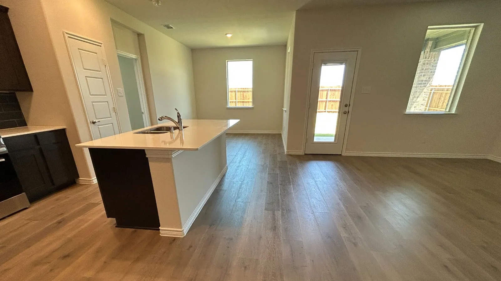 Central kitchen island with an undermount sink and light-toned countertop