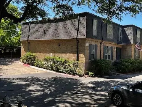 Brick exterior with a dark shingle mansard roof