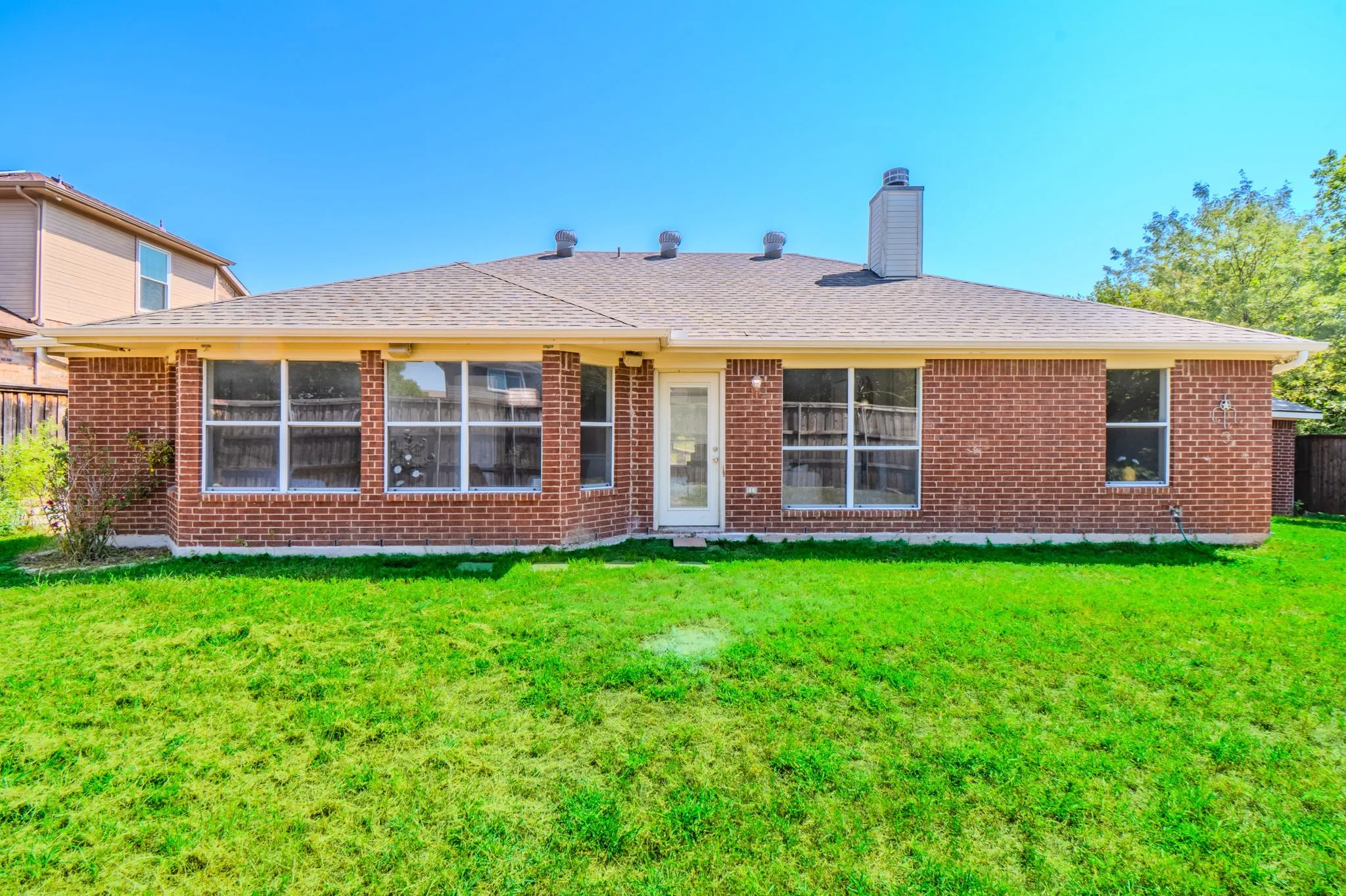 Expansive green lawn bordering the brick exterior with multiple windows