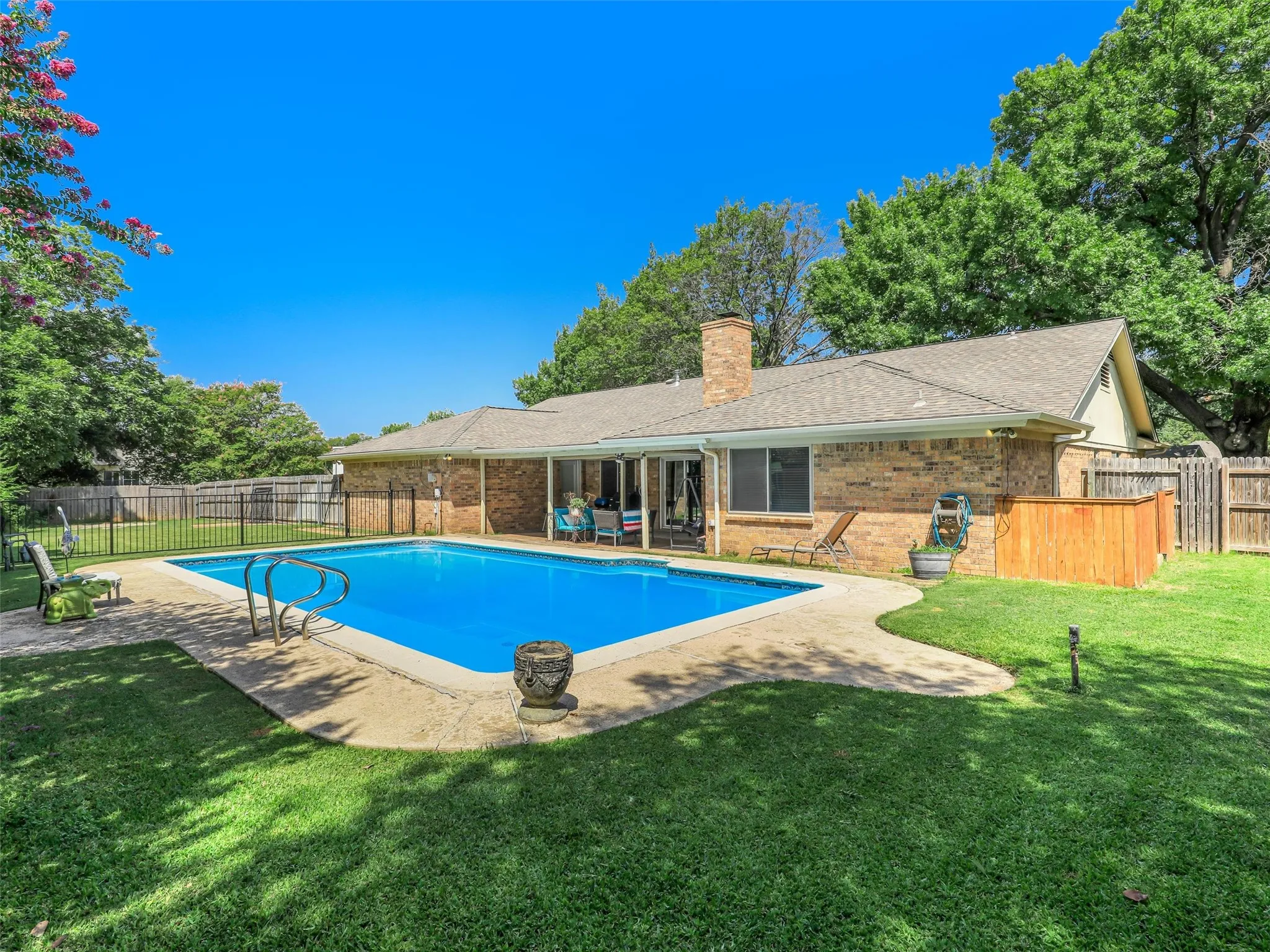 Rectangular swimming pool with integrated steps, surrounded by a concrete patio