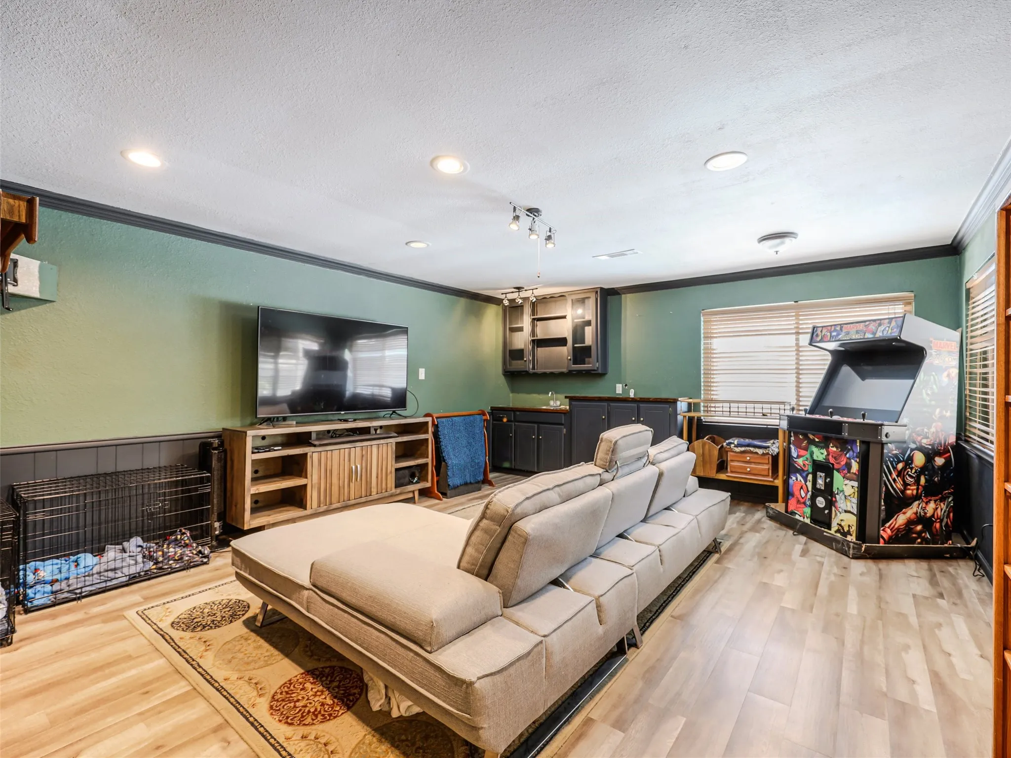 Recreation room featuring wood-finish flooring, recessed lighting, and a built-in wet bar with dark cabinetry