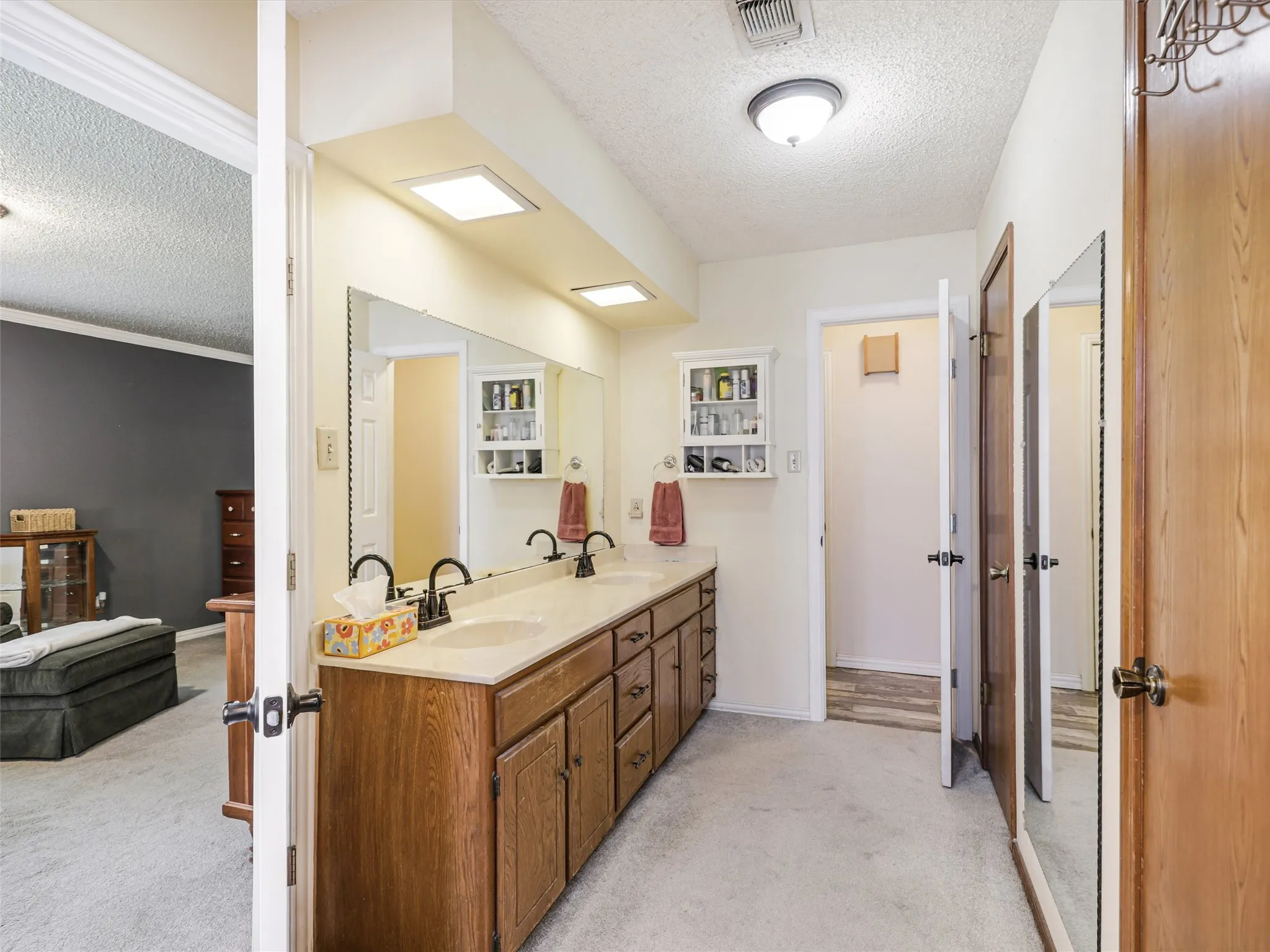 Bathroom vanity with dual undermount sinks, stone-finish countertop, and wood-finish cabinetry