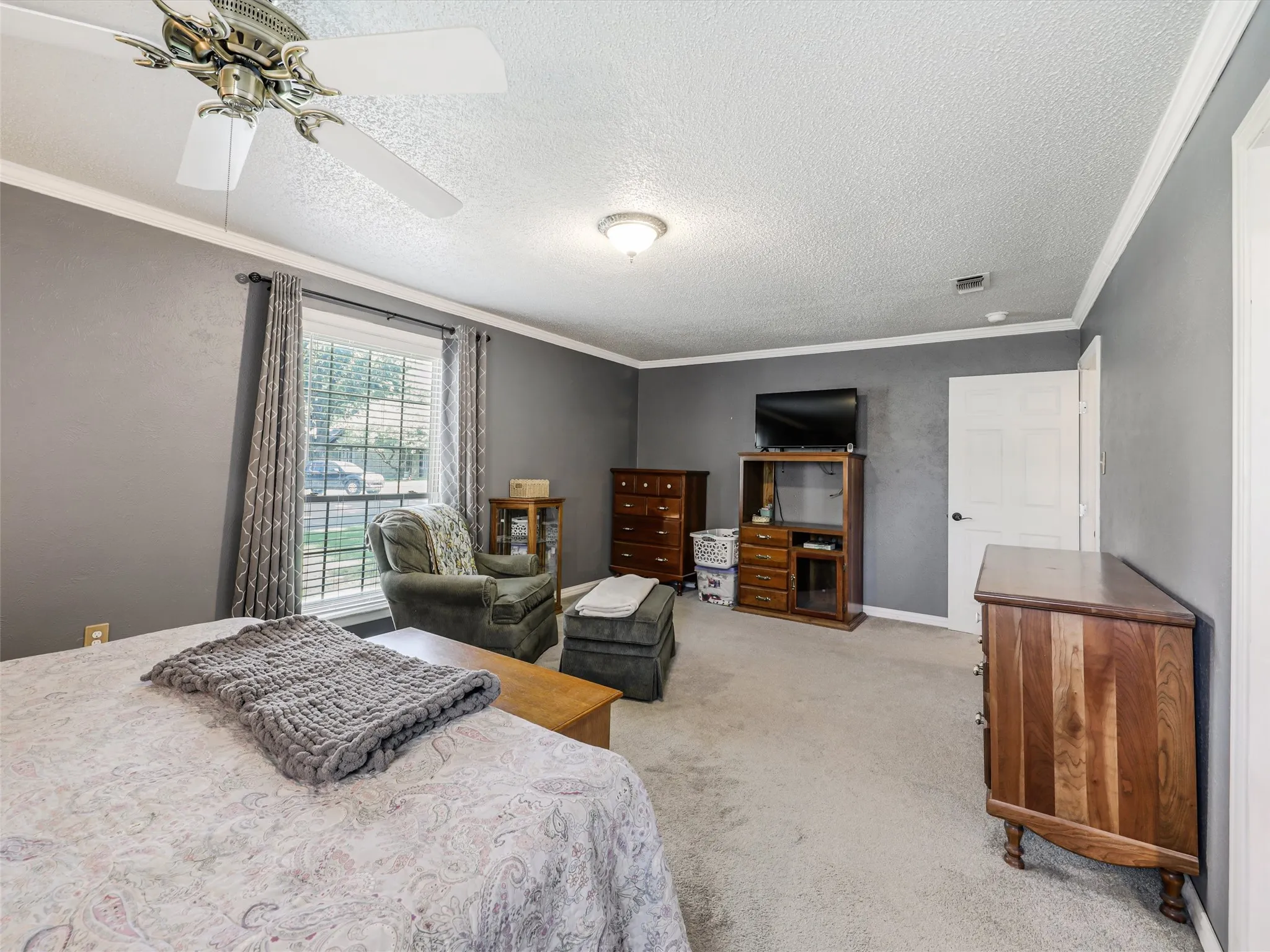 Spacious interior room featuring gray painted walls and light gray carpeted flooring