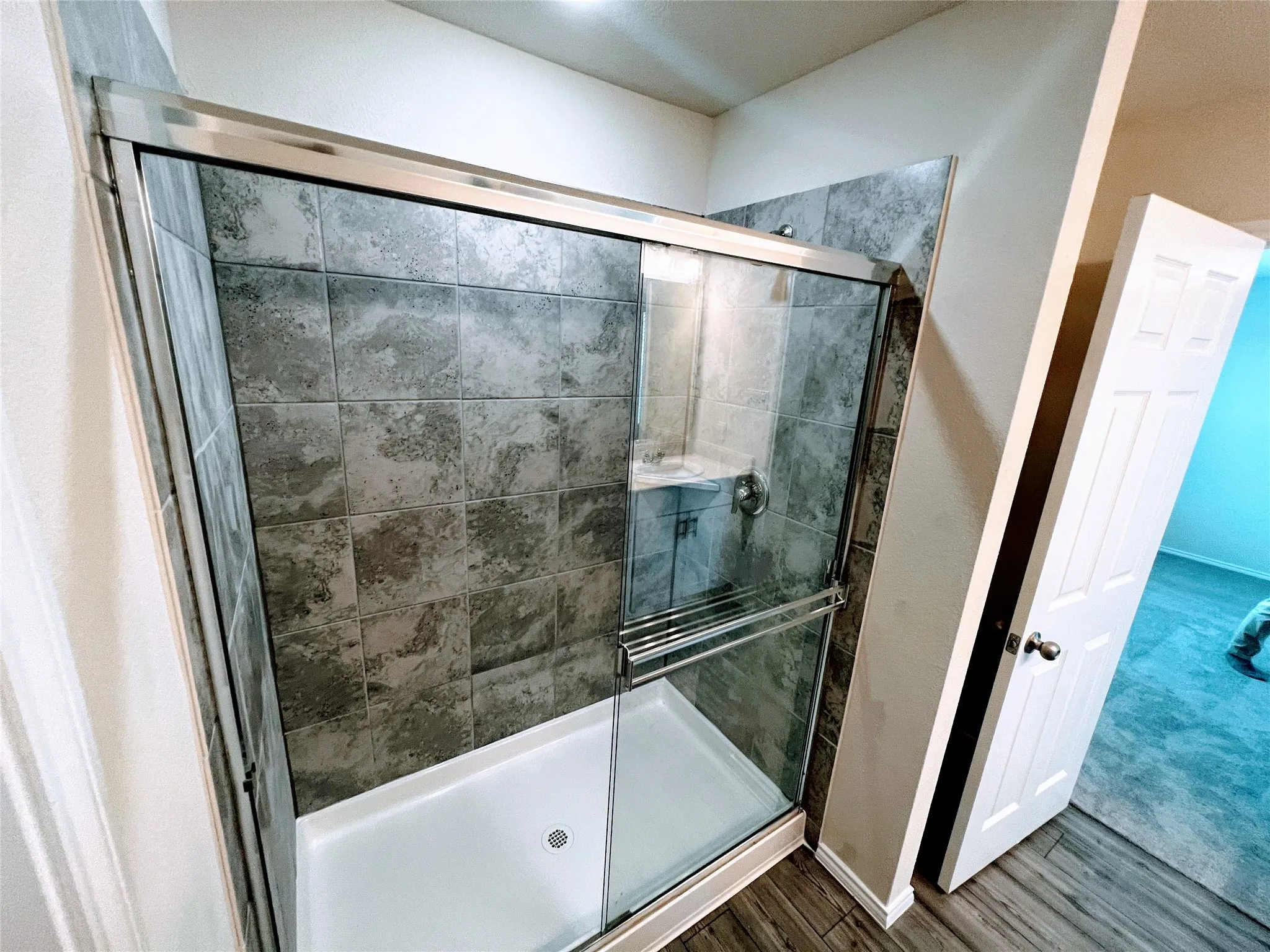 Shower enclosure with a white base and sliding glass doors