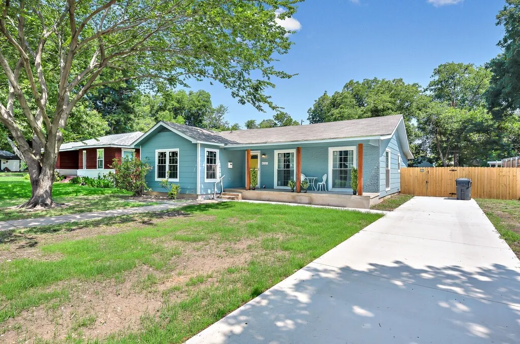 Light blue exterior with white trim and a contrasting yellow front door