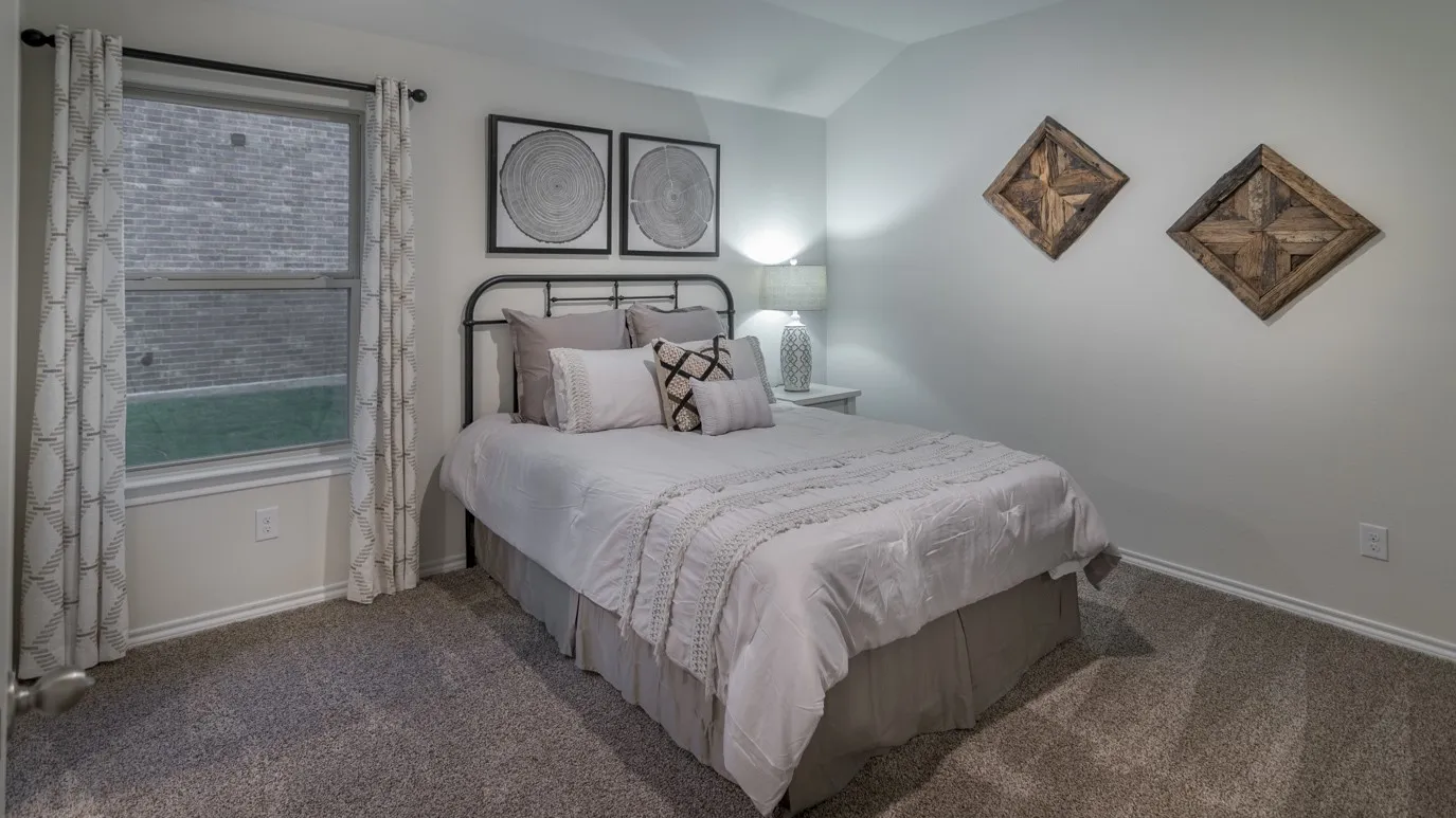Carpeted bedroom featuring a double-hung window, crown molding, and a sloped ceiling