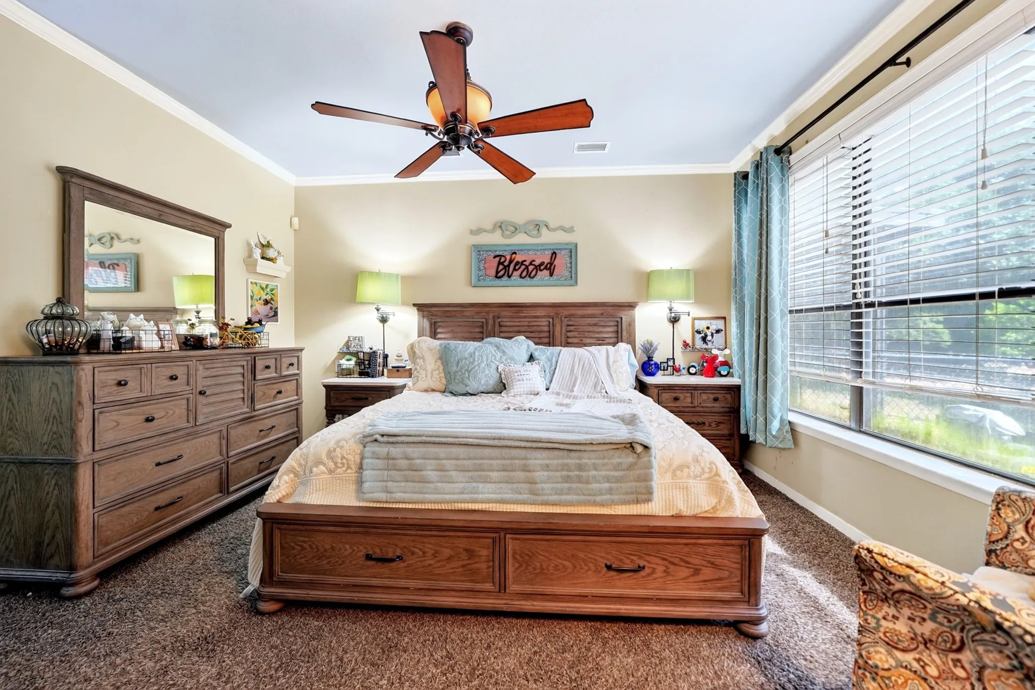 Bedroom featuring a ceiling fan, crown molding, and a large window with blinds